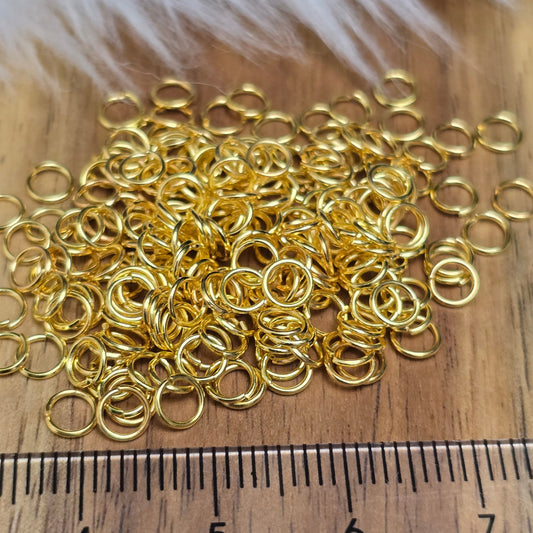 Das Bild zeigt 100 offene Biegeringe in vergoldet mit einem Durchmesser von 4mm, ein unverzichtbares Zubehör für die Schmuckherstellung. Ideal um Charms und Verschlüsse zuverlässig zu befestigen.