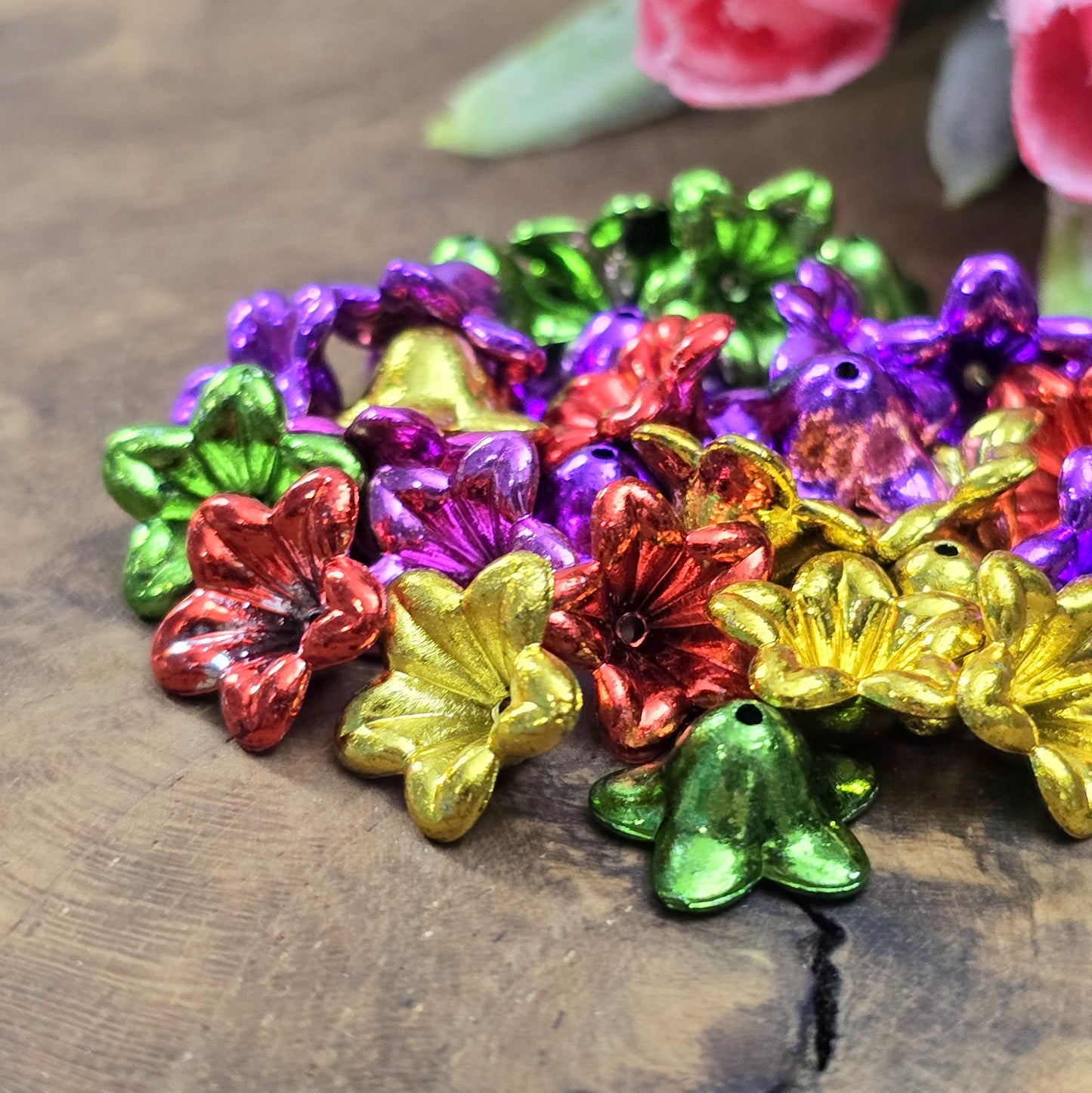 100 Blumenperlen im bunten Farbmix, jede mit einem Durchmesser von 1,2 cm. Die Perlen sind mit metallisch glänzender Oberfläche. Mit dem praktischen Loch zum Auffädeln sind sie ideal für eine Vielzahl kreativer Projekte. Bitte beachte, dass es sich hierbei um Perlen aus II Wahl handelt.