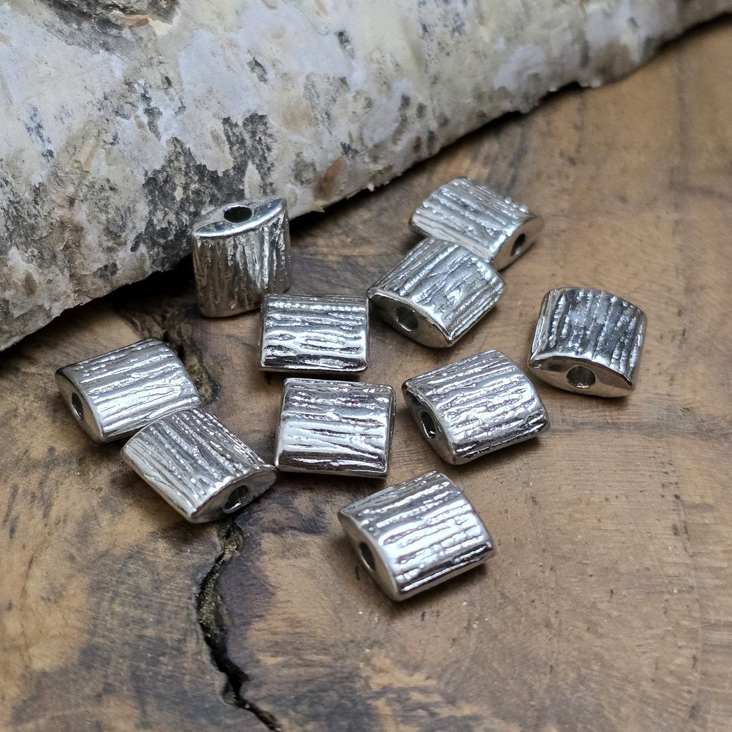 10 antiksilberfarbene Metallperlen in Kissenform, 8 x 8 mm, mit strukturierter Oberfläche. Ideal für Schmuckdesigns wie Ketten, Armbänder oder kreative Dekorationen. Sie setzen stilvolle Akzente in jedem Projekt.