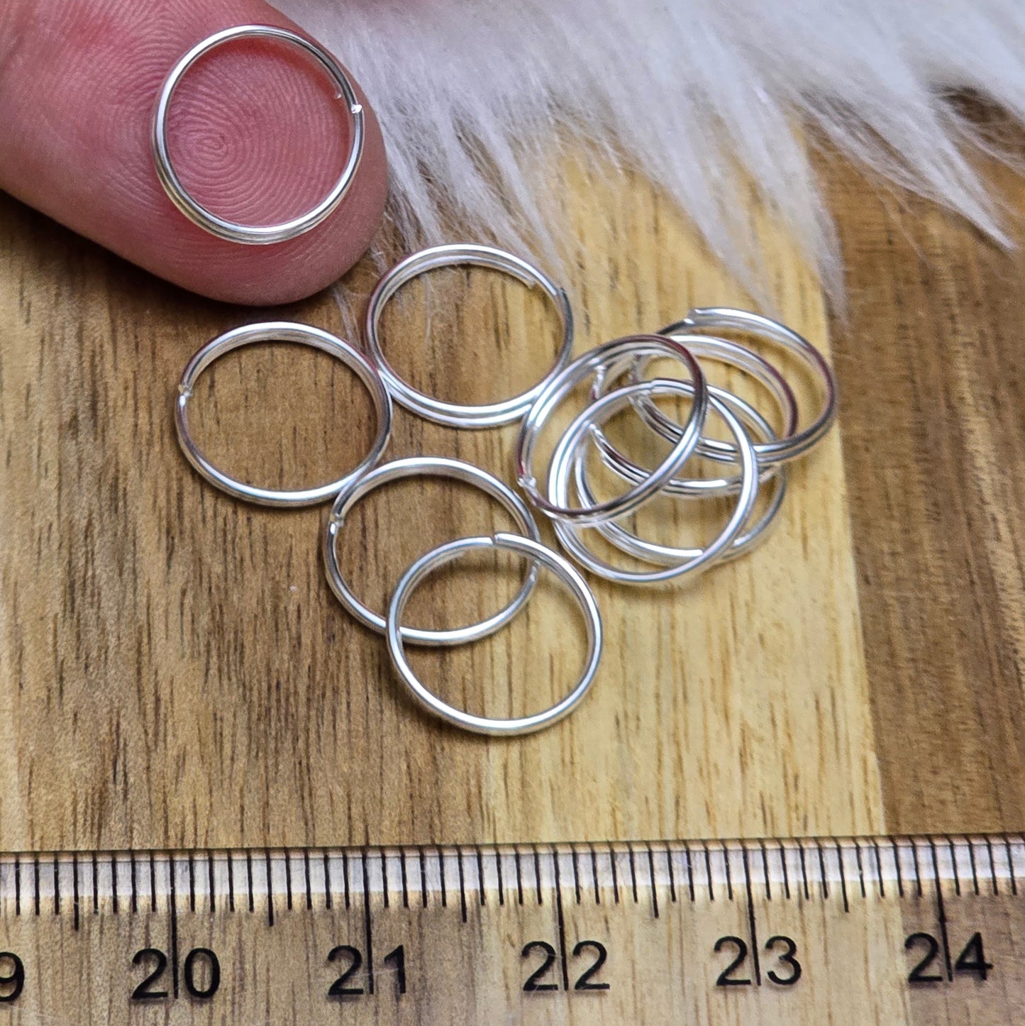 Das Bild zeigt 10 doppelte Binderinge in versilbert mit einem Durchmesser von 12mm. Die Verbindungsringe sind ein unverzichtbares Zubehör für die Schmuckherstellung. Durch ihre doppelte Wicklung bieten sie eine besonders stabile und sichere Verbindung, sodass Anhänger, Charms und Verschlüsse zuverlässig befestigt bleiben.