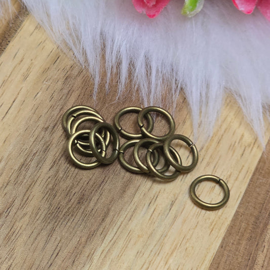 Das Bild zeigt 12 offene Biegeringe in antik bronzefarbig mit einem Durchmesser von 8mm. Die Verbindungsringe sind ein unverzichtbares Zubehör für die Schmuckherstellung. Ideal um Charms und Verschlüsse zuverlässig zu befestigen.