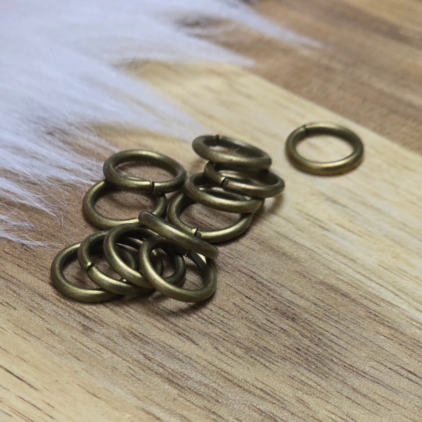 Das Bild zeigt 12 offene Biegeringe in antik bronzefarbig mit einem Durchmesser von 8mm. Die Verbindungsringe sind ein unverzichtbares Zubehör für die Schmuckherstellung. Ideal um Charms und Verschlüsse zuverlässig zu befestigen.