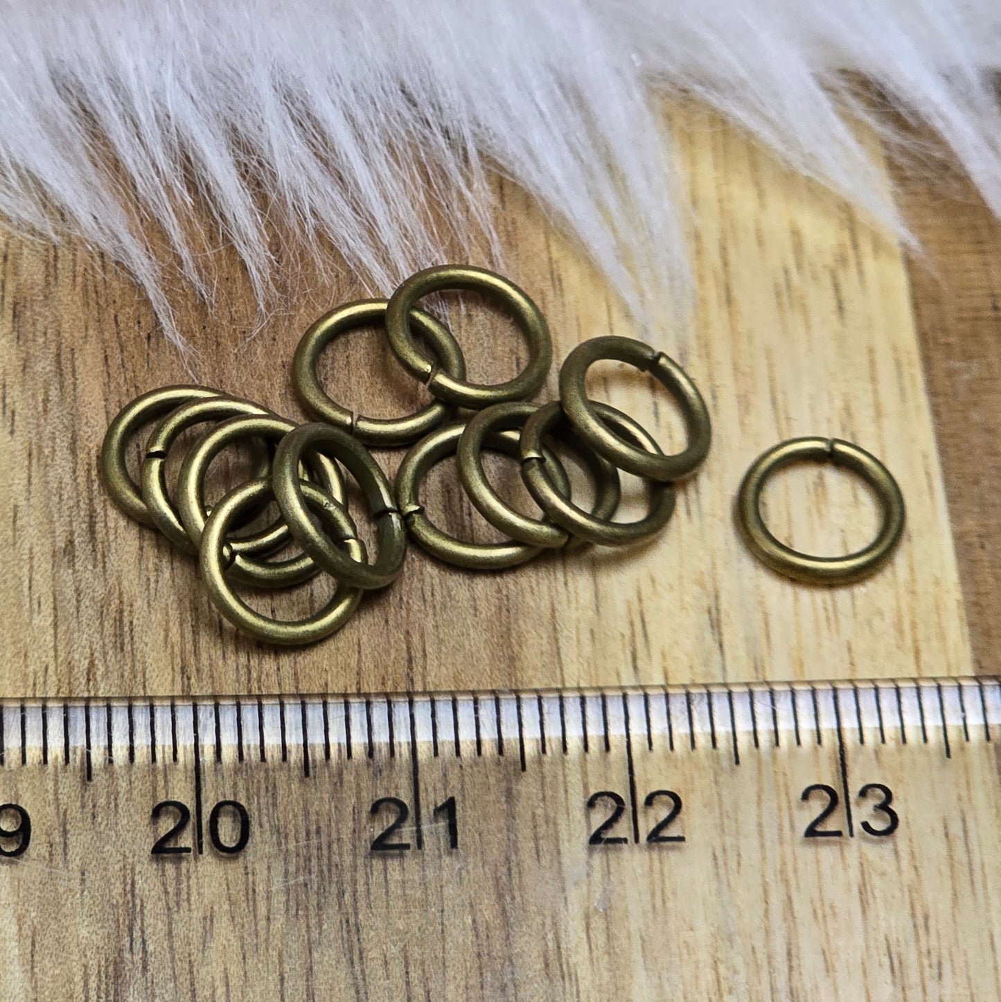 Das Bild zeigt 12 offene Biegeringe in antik bronzefarbig mit einem Durchmesser von 8mm. Die Verbindungsringe sind ein unverzichtbares Zubehör für die Schmuckherstellung. Ideal um Charms und Verschlüsse zuverlässig zu befestigen.