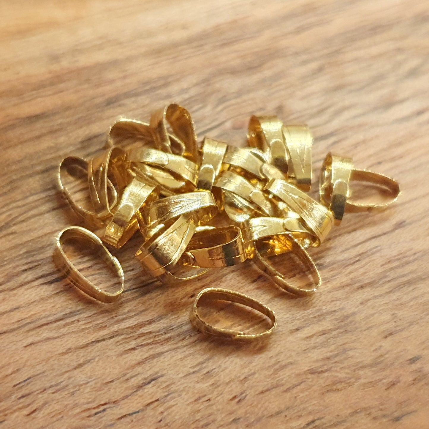 Schlichte und praktische Schlaufen aus vergoldetem Messing. Diese kleinen, aber essentiellen Schlaufen sind unverzichtbar für die Fertigstellung von Anhängern um sie an Ketten und Bändern anbringen zu können. Die Schlaufen sind leicht oval und konisch gestaltet. Im oberen Teil etwas breiter und unten etwas schmaler. Sie lassen leicht auf & zu biegen.