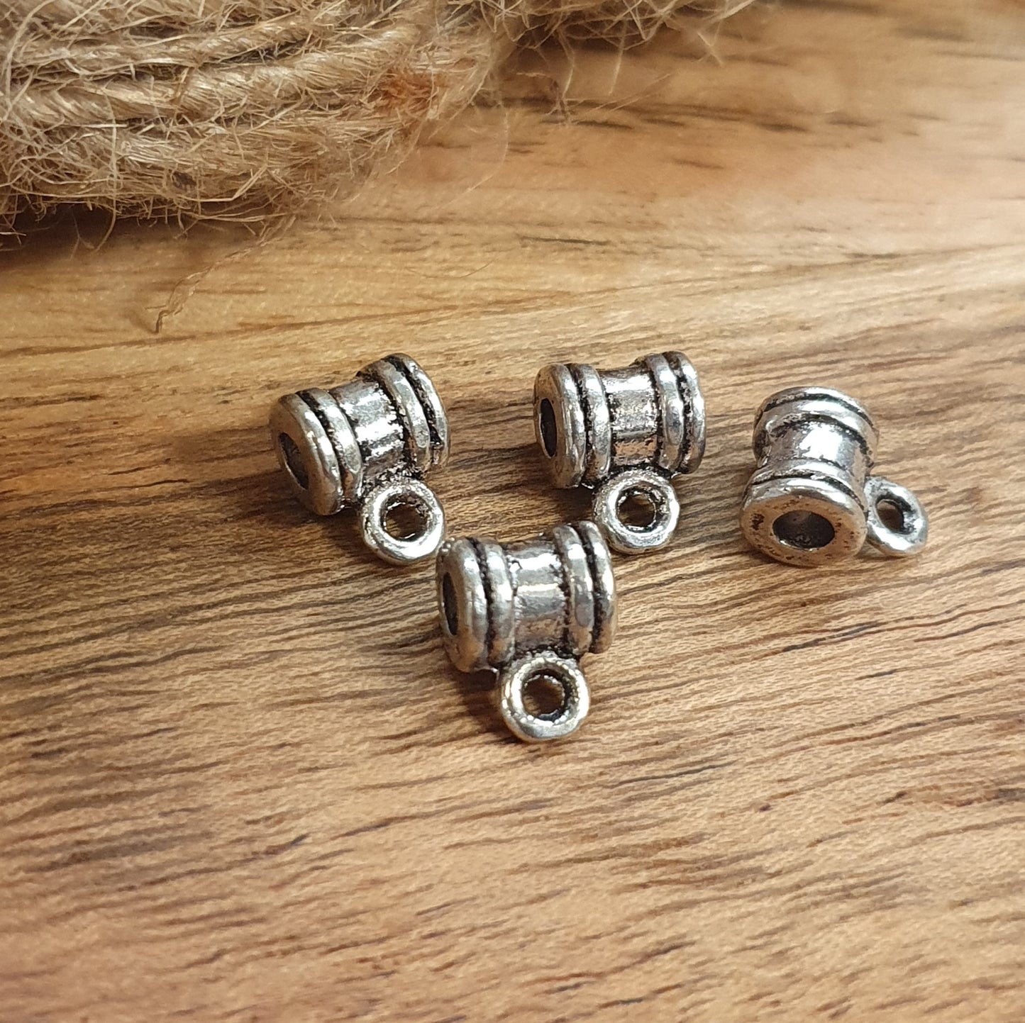 Sie erhalten hier 4 Ösenperlen in schlichtem Ethno-Design und einem tollem antik silbernem Finish. Die Perlen sind länglich gearbeitet und haben eine kleine Öse. Man kann sie z.B. in ein Armband oder Kette einarbeiten und einen kleinen Anhänger anbringen. Die Mitte der länglichen Form kann noch verziert werden mit Strass, Stoff oder Farbe. Das Band sollte nicht dicker als 3mm sein. Ideal auch für Makramee oder zum Einarbeiten in Makramee-Dreads und Hairwraps.