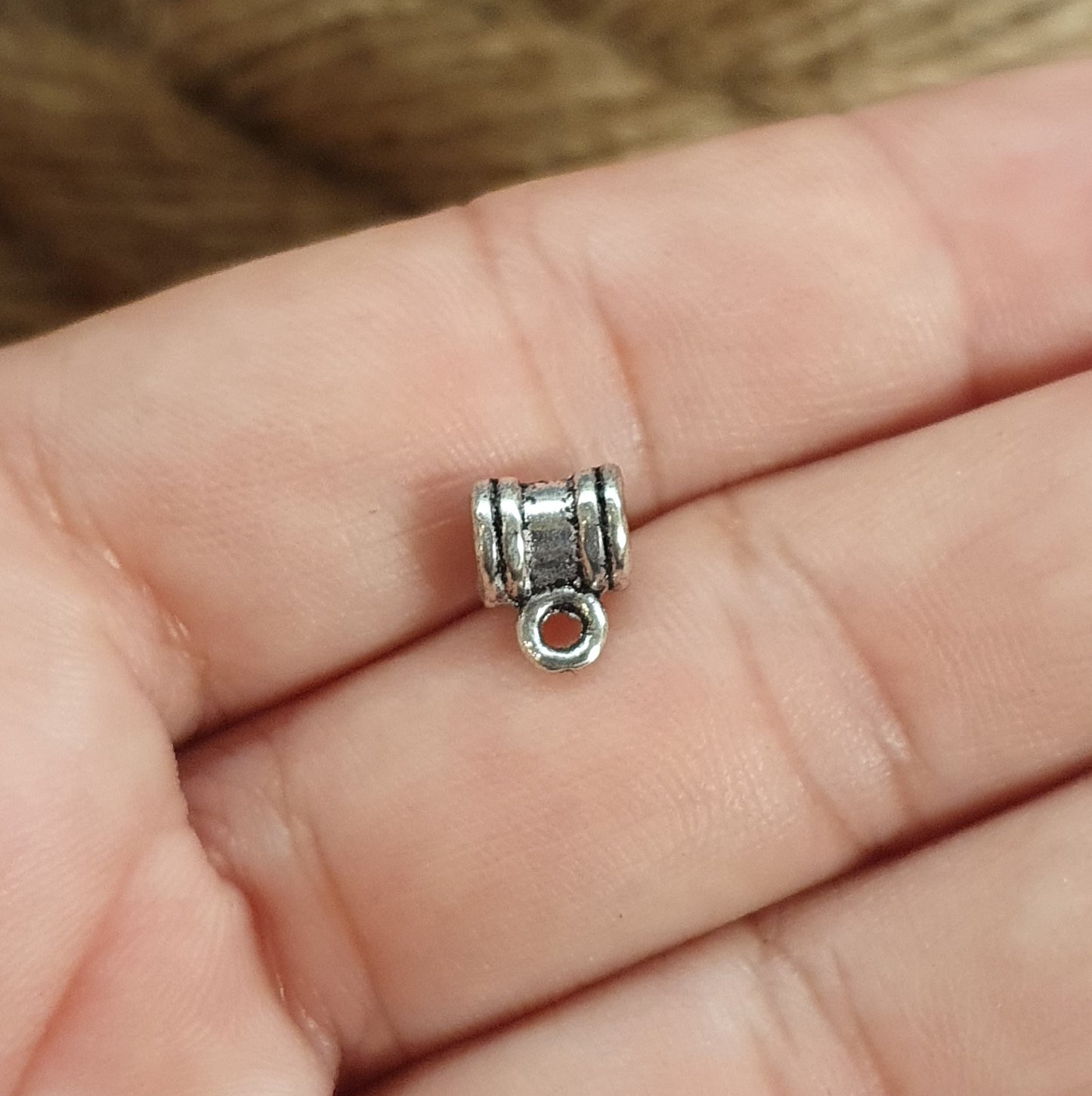 Sie erhalten hier 4 Ösenperlen in schlichtem Ethno-Design und einem tollem antik silbernem Finish. Die Perlen sind länglich gearbeitet und haben eine kleine Öse. Man kann sie z.B. in ein Armband oder Kette einarbeiten und einen kleinen Anhänger anbringen. Die Mitte der länglichen Form kann noch verziert werden mit Strass, Stoff oder Farbe. Das Band sollte nicht dicker als 3mm sein. Ideal auch für Makramee oder zum Einarbeiten in Makramee-Dreads und Hairwraps.