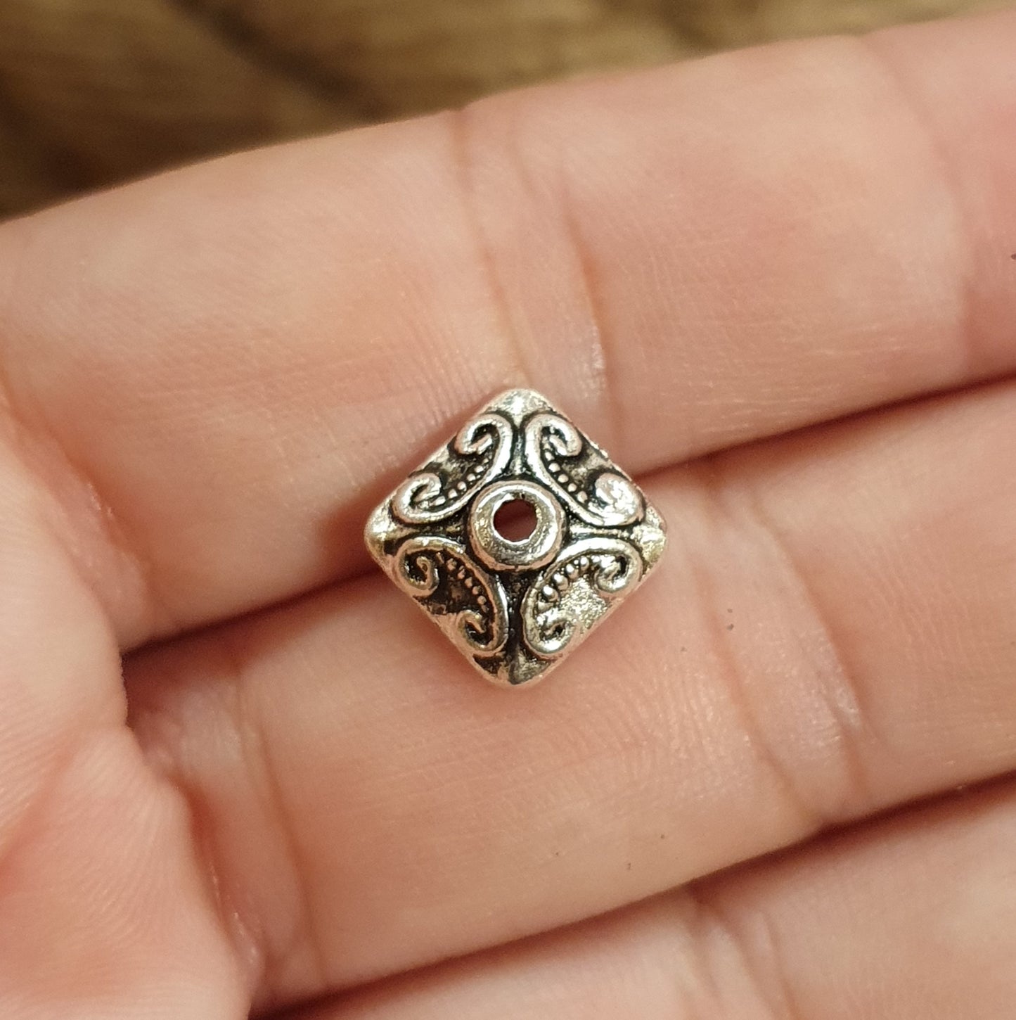 6 tolle Perlenkappen in 4eck-Form mit Schnörkeldesign und antikem Finish. Super geeignet zum Verzieren von Perlen aus Glas oder Edelsteinen und schützen die Perle vor Stößen von benachbarten Perlen. Sie verleihen außerdem jedem Schmuckstück ein antikes und raffiniertes Aussehen. Die Kappen können auch als Zierelement in Stoffblumen aus Satin oder Schleifen, sowie auf Kisten, Bilderrahmen, Grußkarten und vielem mehr verwendet werden.