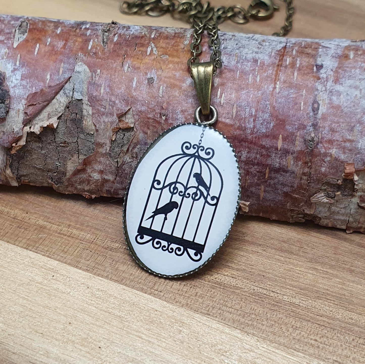 Zarte Anhängerkette im Vintage-Stil mit leichtem Anhänger. Motiv Vögel im Käfig, antik bronzefarbig