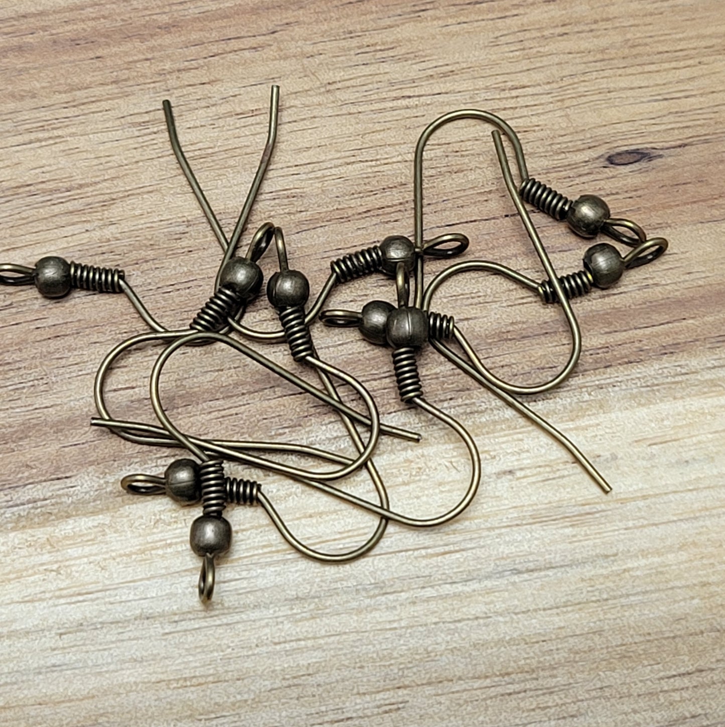 Schlichte Ohrhakten für die individuelle Schmuckherstellung oder als Ersatzteil geeignet. Die einfachen Haken sind mit einer Spirale und einer Kugel verziert. An der unteren Öse kann ein Anhänger angebracht werden. Die Öse zeigt bei diesen Ohrhaken zur Seite. Die Haken werden einfach in das Ohrloch eingehängt und sind somit leicht an- & abzulegen.