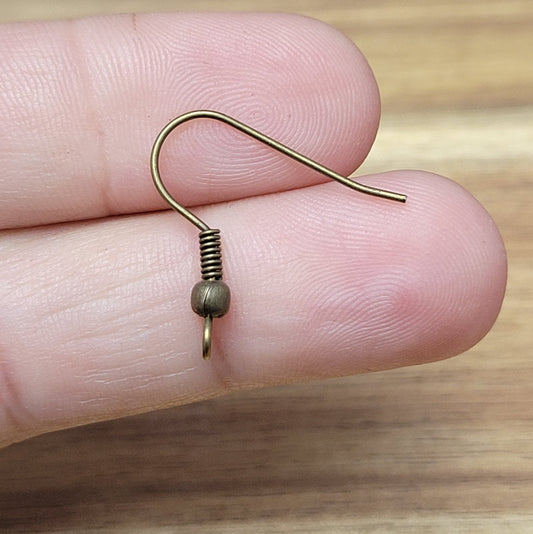 Schlichte Ohrhakten für die individuelle Schmuckherstellung oder als Ersatzteil geeignet. Die einfachen Haken sind mit einer Spirale und einer Kugel verziert. An der unteren Öse kann ein Anhänger angebracht werden. Die Öse zeigt bei diesen Ohrhaken zur Seite. Die Haken werden einfach in das Ohrloch eingehängt und sind somit leicht an- & abzulegen.