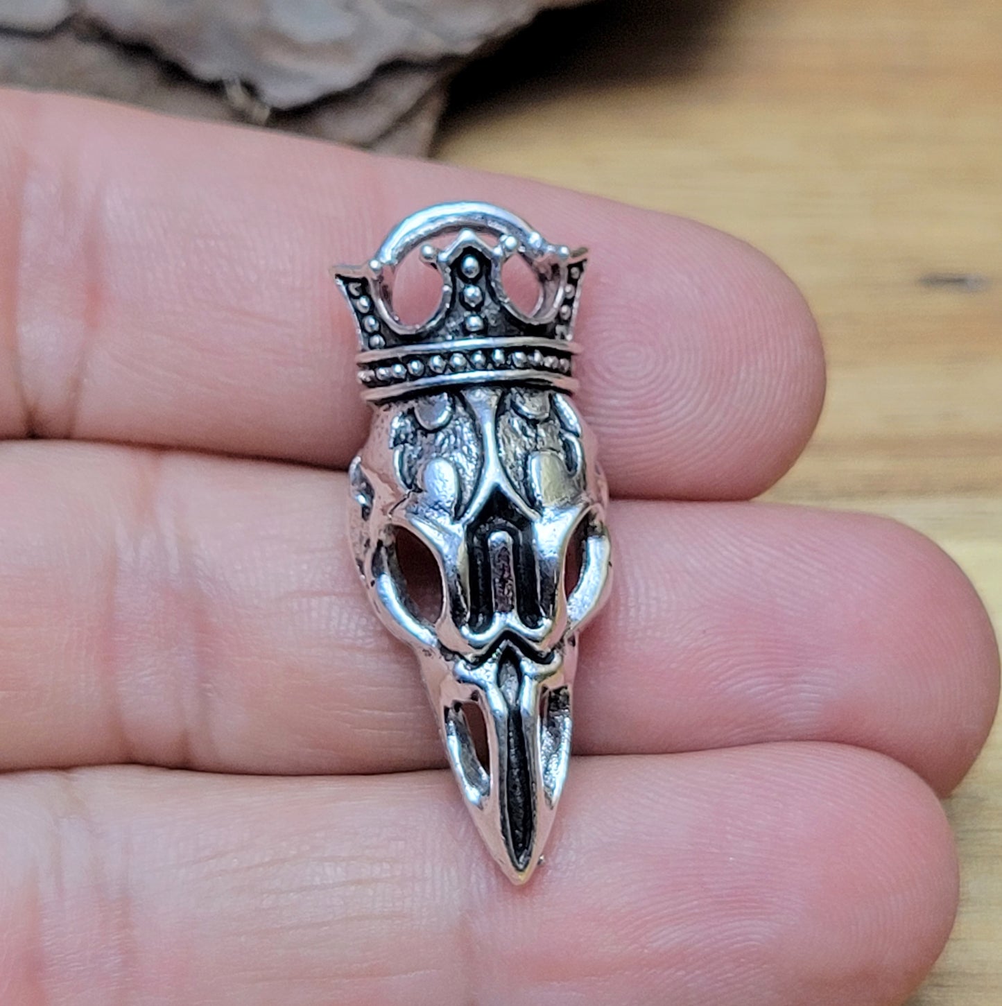 Anhänger Krähenschädel mit Krone und antik Silberfinish für einen mystischen und zeitlosen Look. Der Anhänger hat oben am Schädel eine feste Öse und eignet sich hervorragend für die individuelle Schmuckherstellung. Ideal als Anhänger für Ketten & Choker und natürlich für allerlei Accessoires wie Taschenschmuck, Schlüsselanhänger. Macht sich gut an Lederbändern für Herrenschmuck.