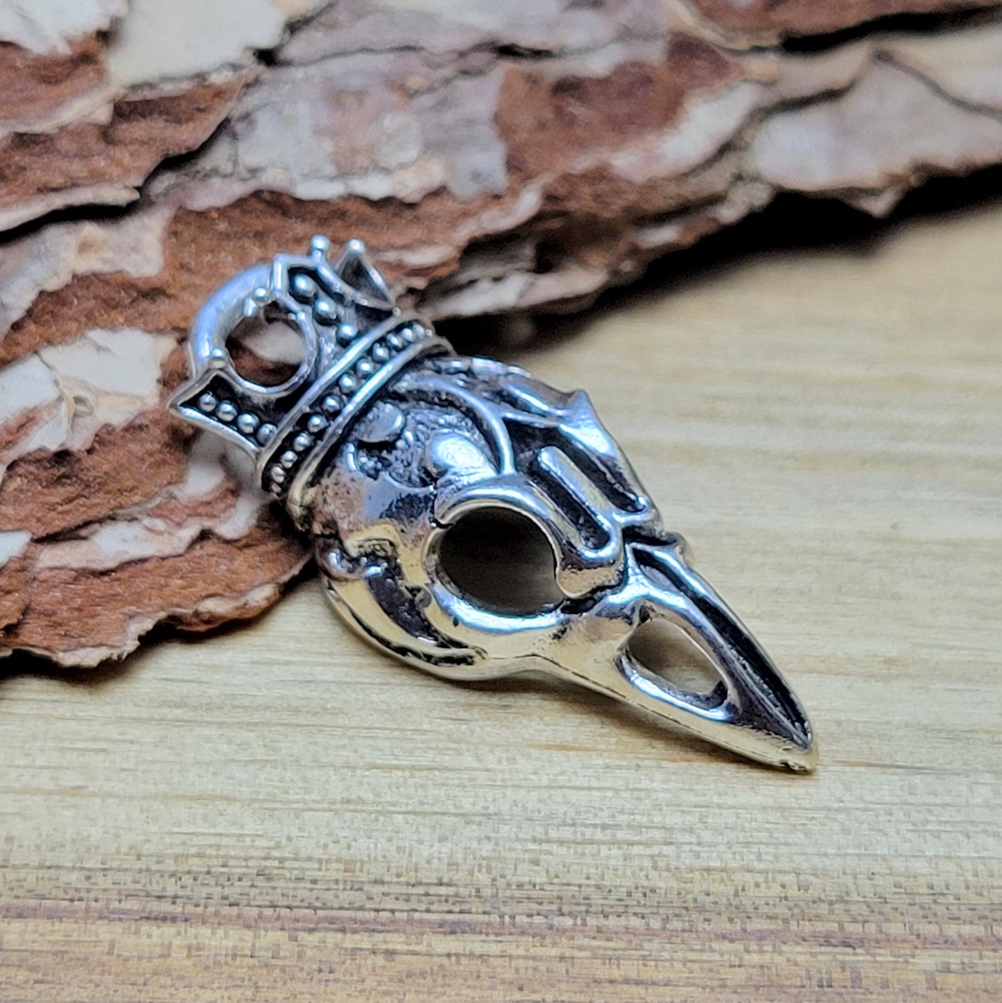 Anhänger Krähenschädel mit Krone und antik Silberfinish für einen mystischen und zeitlosen Look. Der Anhänger hat oben am Schädel eine feste Öse und eignet sich hervorragend für die individuelle Schmuckherstellung. Ideal als Anhänger für Ketten & Choker und natürlich für allerlei Accessoires wie Taschenschmuck, Schlüsselanhänger. Macht sich gut an Lederbändern für Herrenschmuck.