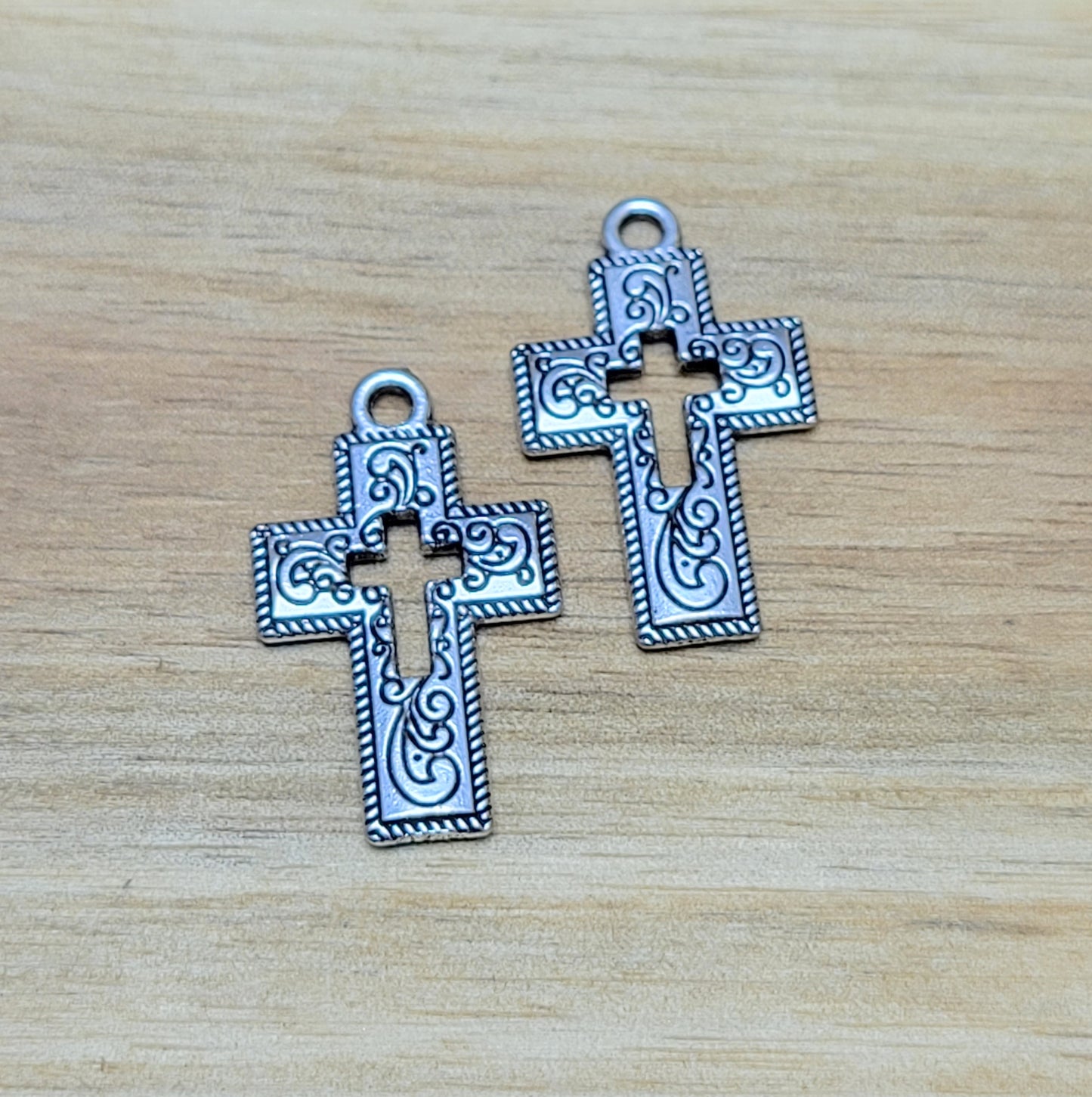 Charmante Kreuz-Anhängern in antik silberfarbiger Ausführung. Mit einer Größe von 23 mm sind sie ideal für Ihre individuelle Schmuckherstellung. Perfekt für Dirndlschmuck, Taschenschmuck, Ohrschmuck, Armbänder, Ketten & Choker oder Trachtenaccessoires. Die Kreuz-Anhänger sind mit Verzierungen versehen und einem Kreuz in der Mitte als Cutout. Ihre beidseitige geprägung macht sie vielseitig in der Verwendung.