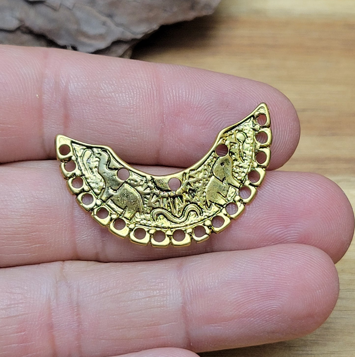 2 einzigartige, halbrunde Multiverbinder im Bollywood-Stil. Die ideale Schmuckkomponente für Tiaras, Fußschmuck, Handketten und Ohrschmuck im beliebt indischen Bollywood-Design. Die Verbinder sind antik silberfarbig und verfügen im inneren Bogen über 3 Löcher und am unteren Außenbogen befinden sich 17 Löcher. Auf dem Bogen selbst sind 2 Elefanten abgebildet sowie eine Sonne.