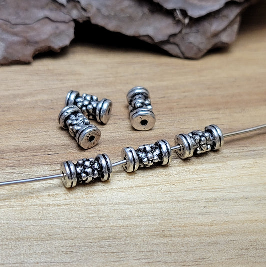 12 Ethno Metallperlen Tube, Walze, 7x3mm, antik silberfarbig
Setze eindrucksvolle Akzente in deinen Schmuckkreationen mit diesen 12 kleinen, walzenförmigen Metallperlen, die mit einem ansprechenden Ethno-Muster versehen sind.