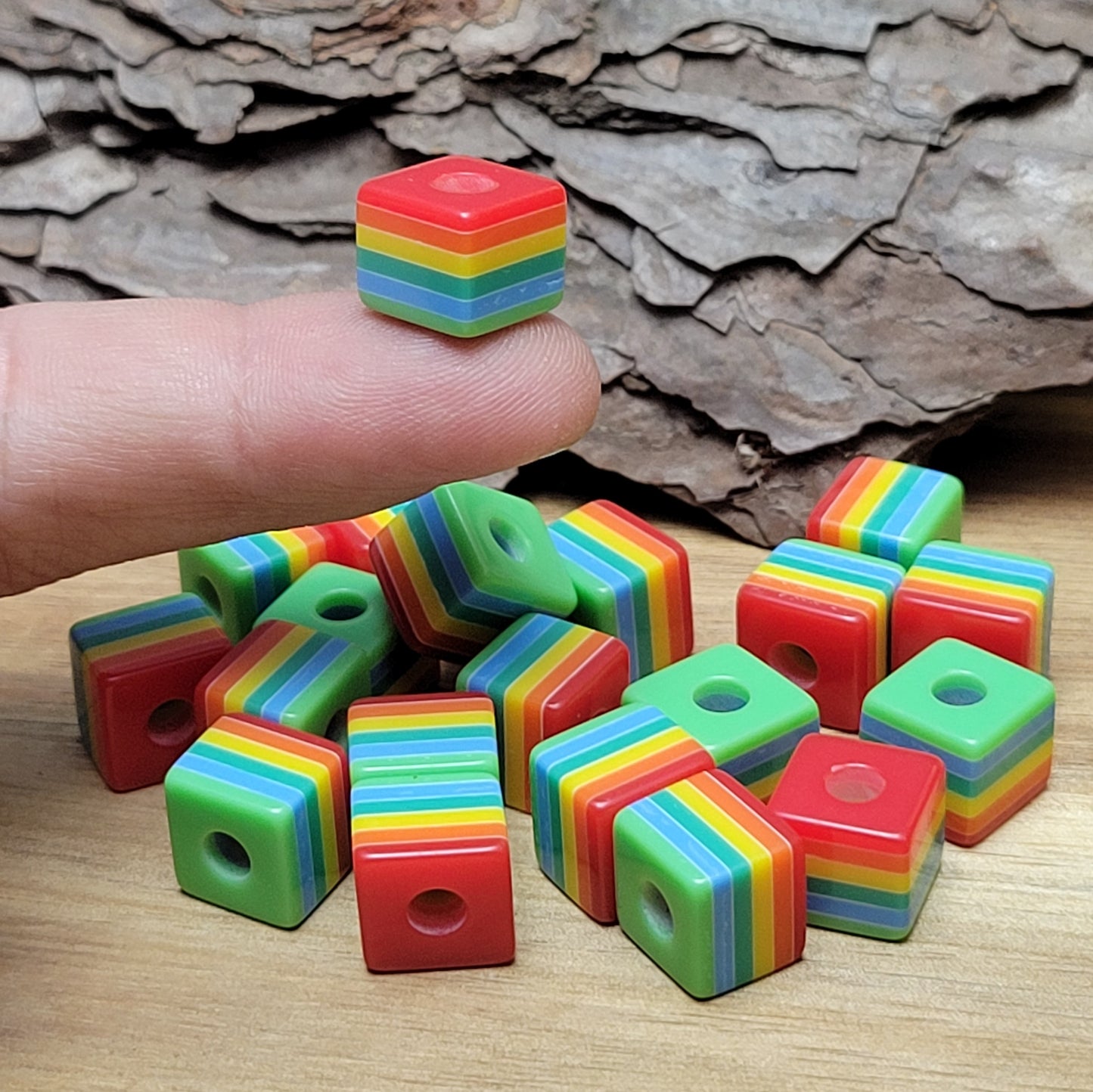 20 regenbogenfarbigen Würfelperlen aus Resin. Diese vielseitigen Perlen sind eine Bereicherung für Ihre kreativen Projekte. Die Verwendungsmöglichkeiten sind schier endlos: Nutzen Sie diese Perlen für die Schmuckherstellung, z.B. bei der Gestaltung von Makramee-Armbändern oder Ketten. Schaffen Sie einzigartige Dekorationsartikel oder lassen Sie Ihrer Fantasie bei anderen Bastelprojekten freien Lauf.