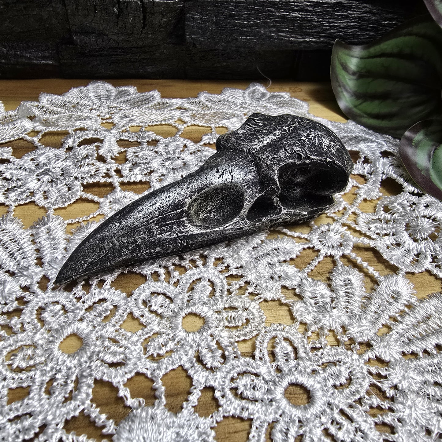 Das Bild zeigt einen Krähenschädel Dekofigur schwarz/silber, 10 cm, aus Kunststein, Hexenaltar, Altarschmuck, gotisches Wohndekor, Rabenschädel
Dieser mystische Krähenschädel aus Kunststein ist ein faszinierendes Schmuckstück für jedes gotische Wohndekor und ein kraftvolles Element für Ihren Hexenaltar.