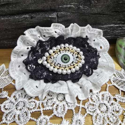 Das Bild zeigt eine tolle Haarspange Auge mit romantischer weiße Rüsche
Die Haarspange, die dich (und alle anderen) im Auge behält 👁️
Diese Haarspange ist nicht nur ein Accessoire – sie ist ein Gesprächsstarter! Mit ihrem mystischen Auge, umrahmt von Strass, goldfarbigen und weißen Kunststoffperlen sowie einer romantischen schwarzen und weißen Rüschen, kombiniert sie einen Hauch von Gothic-Chic mit einer Prise Kurioses.
