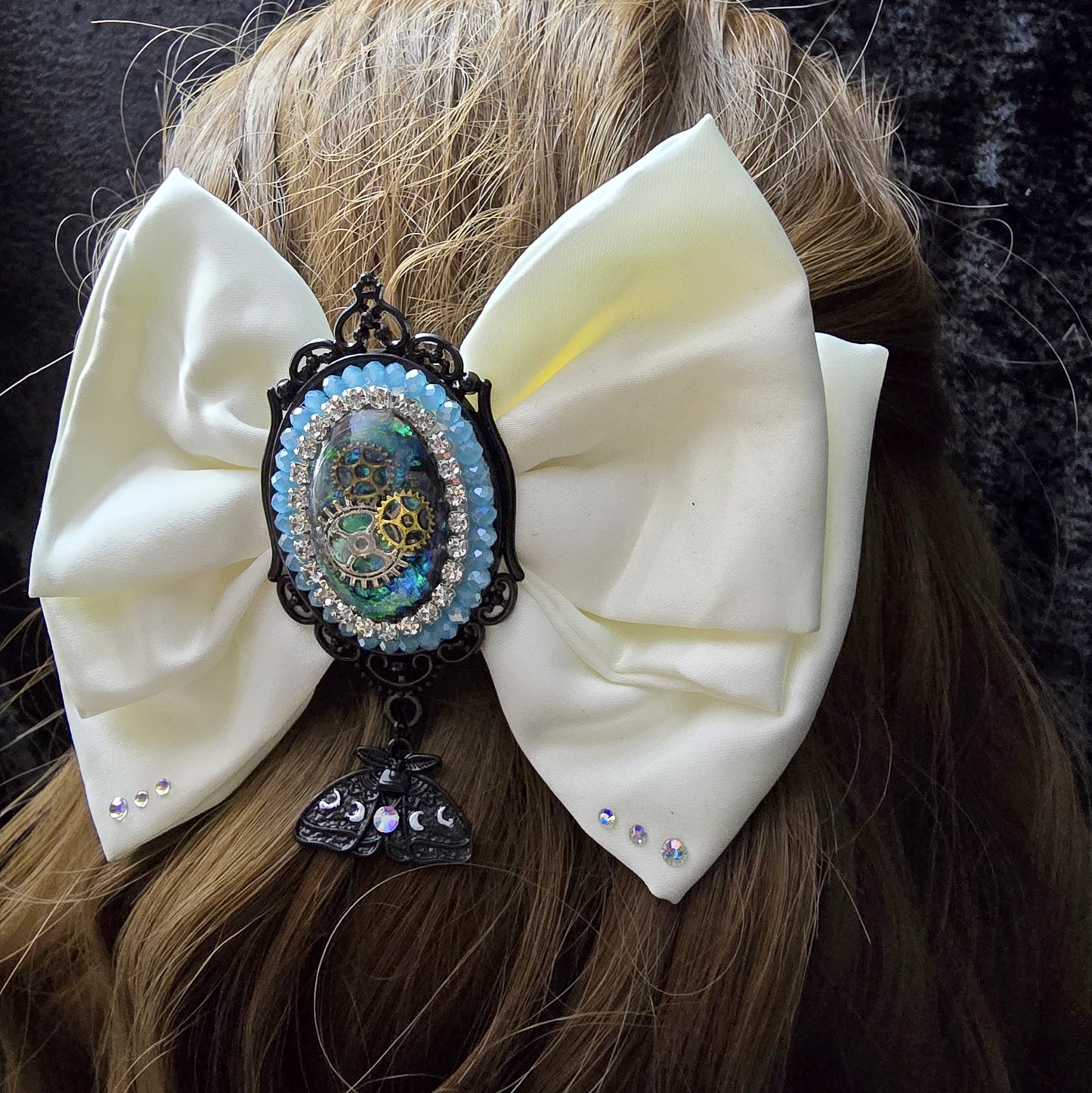 Das Bild zeigt Einzigartige Steampunk Haarspange mit weißer Schleife und handgefertigem Zierteil
Hier trifft sich eine außergewöhnlichen Mischung aus eleganter Romantik und industriellem Flair.