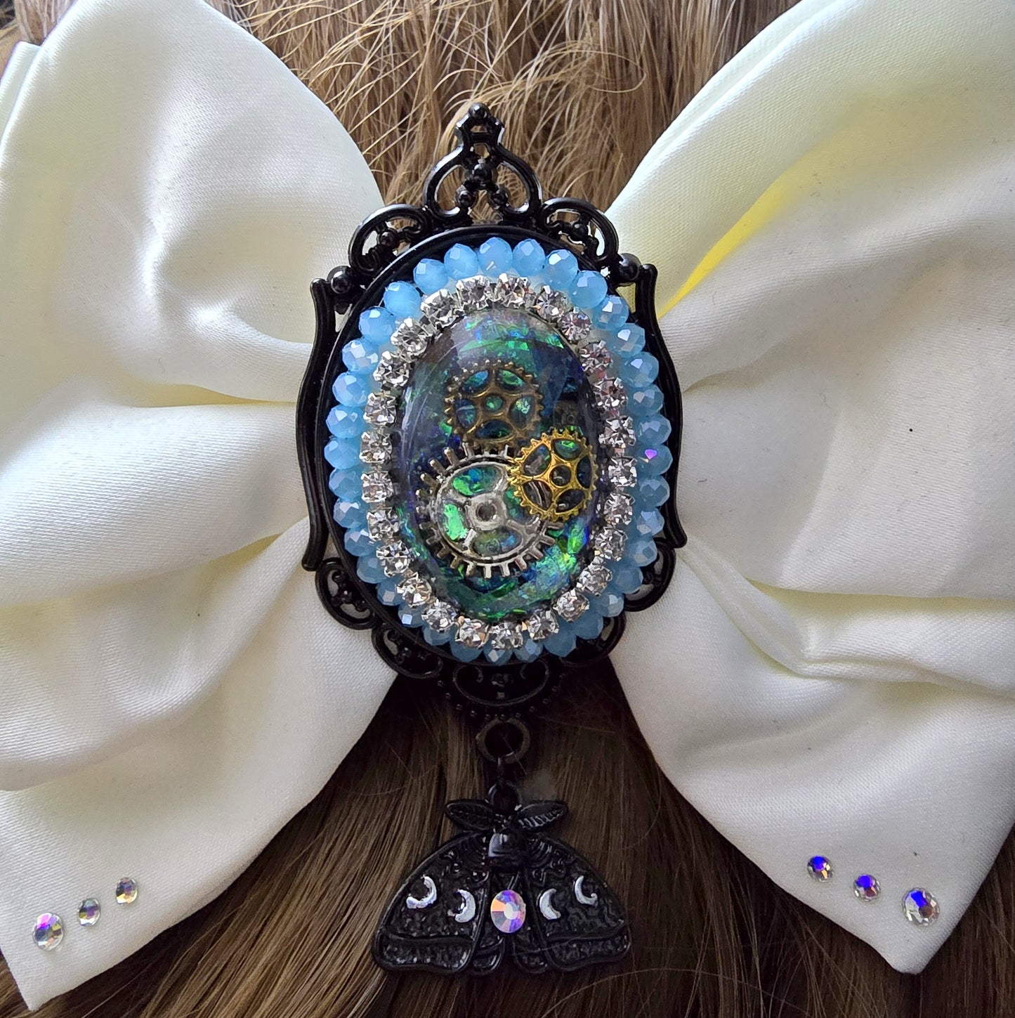 Das Bild zeigt Einzigartige Steampunk Haarspange mit weißer Schleife und handgefertigem Zierteil
Hier trifft sich eine außergewöhnlichen Mischung aus eleganter Romantik und industriellem Flair.