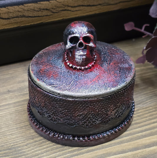 Das Bild zeigt eine gandgemachte Schmuckdose mit Totenkopf, Punk Stil, Rockabilly, Totenkopfliebe, Gothic Style
Ein Hauch von Dunkelheit und Rebellion erwartet dich mit dieser einzigartigen handgemachten Schmuckdose im unverwechselbaren Punk-Gothic-Stil.