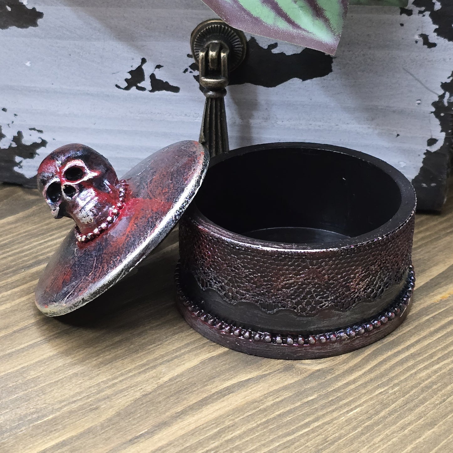 Das Bild zeigt eine gandgemachte Schmuckdose mit Totenkopf, Punk Stil, Rockabilly, Totenkopfliebe, Gothic Style
Ein Hauch von Dunkelheit und Rebellion erwartet dich mit dieser einzigartigen handgemachten Schmuckdose im unverwechselbaren Punk-Gothic-Stil.