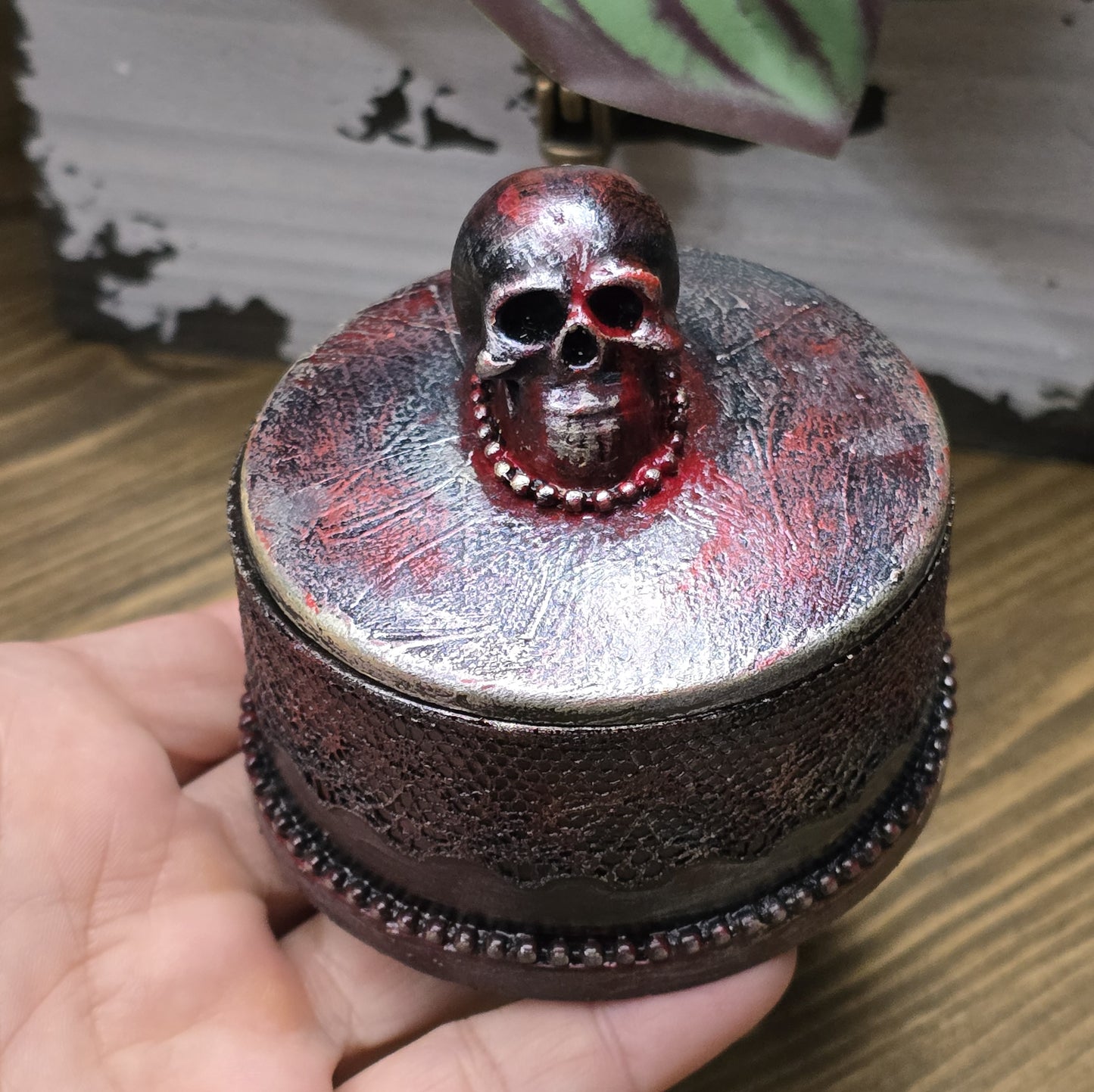 Das Bild zeigt eine gandgemachte Schmuckdose mit Totenkopf, Punk Stil, Rockabilly, Totenkopfliebe, Gothic Style
Ein Hauch von Dunkelheit und Rebellion erwartet dich mit dieser einzigartigen handgemachten Schmuckdose im unverwechselbaren Punk-Gothic-Stil.