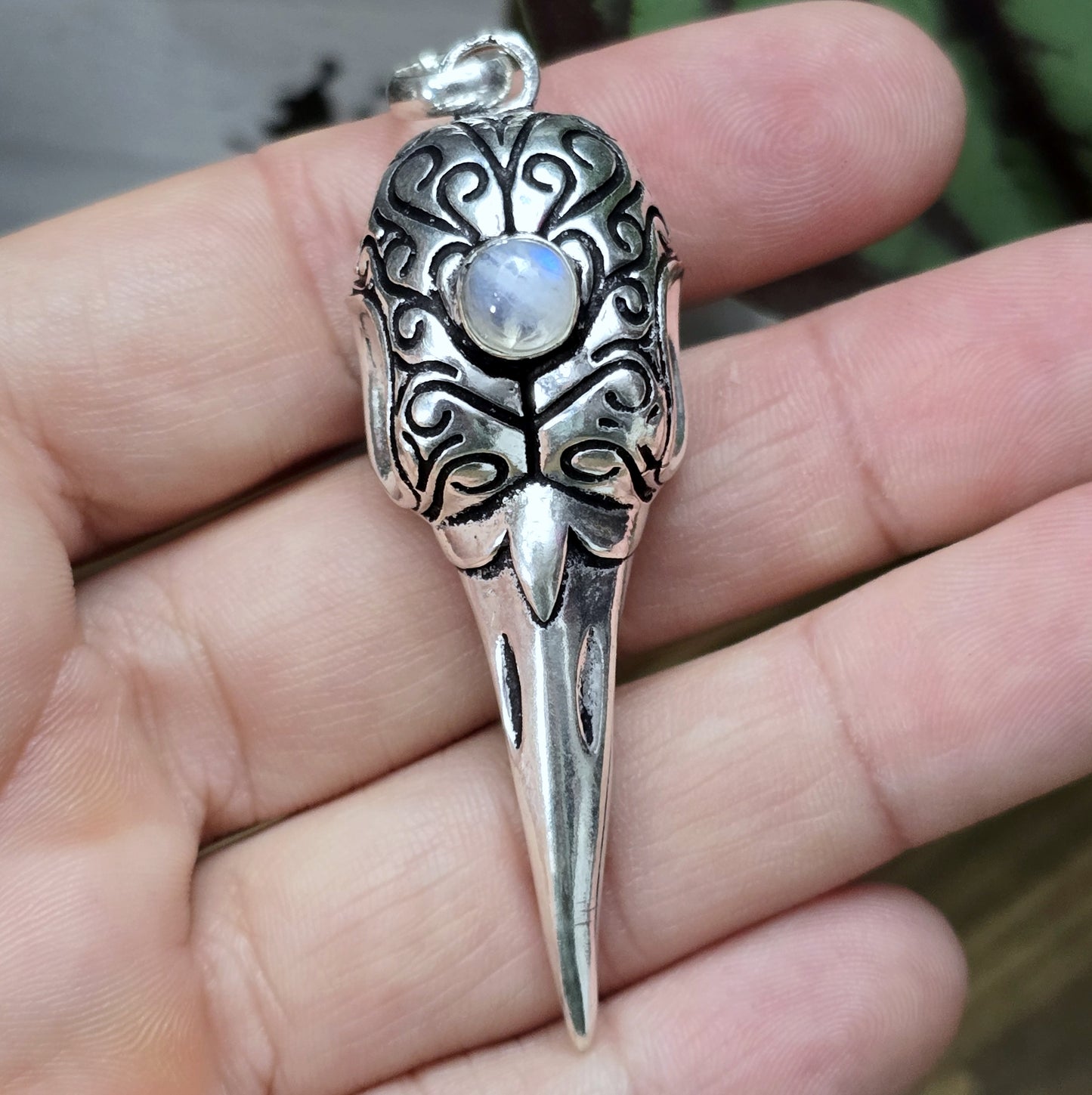 Mystischer Rabenschädel-Anhänger aus .925 Sterling Silber mit einem Regenbogen-Mondstein, ideal für Gothic-, Biker- und Rockabilly-Stile. Der Anhänger vereint düstere Ästhetik und spirituelle Symbolik in einem einzigartigen Design.