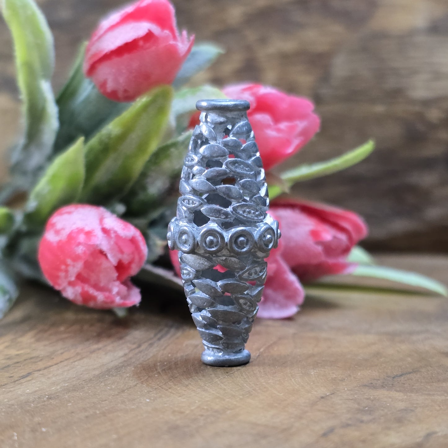 Diese stilvolle Doppelkegel-Metallperle besticht durch ihre detailreichen Verzierungen und filigranen Durchbrüche. Mit ihrer matten, antikfreien Optik harmoniert sie perfekt mit Holzperlen, Edelsteinperlen oder traditionellen afrikanischen Designs.