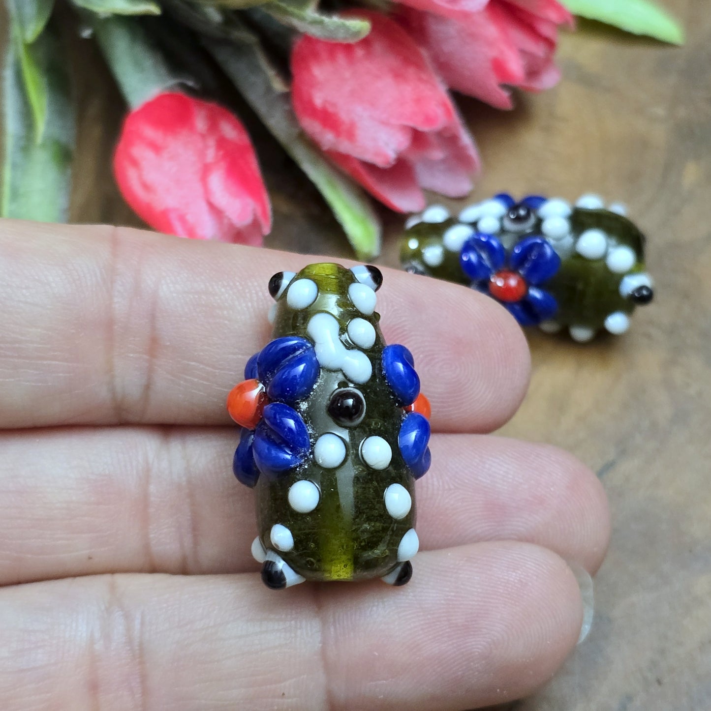 2 Handgemachte indische Glasperlen mit 3D-Blumenmuster in Tropfenform – Dunkelgrün/Blau/Weiß
Diese zauberhaften Glasperlen werden in sorgfältiger Handarbeit gefertigt und bestechen durch ihr opulentes 3D-Muster in Form von Dots und Blumen. Jede Perle ist ein Unikat und bringt einen Hauch traditioneller Handwerkskunst in deine Kreationen.
