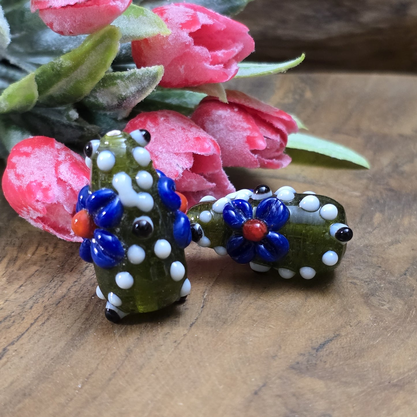 2 Handgemachte indische Glasperlen mit 3D-Blumenmuster in Tropfenform – Dunkelgrün/Blau/Weiß
Diese zauberhaften Glasperlen werden in sorgfältiger Handarbeit gefertigt und bestechen durch ihr opulentes 3D-Muster in Form von Dots und Blumen. Jede Perle ist ein Unikat und bringt einen Hauch traditioneller Handwerkskunst in deine Kreationen.