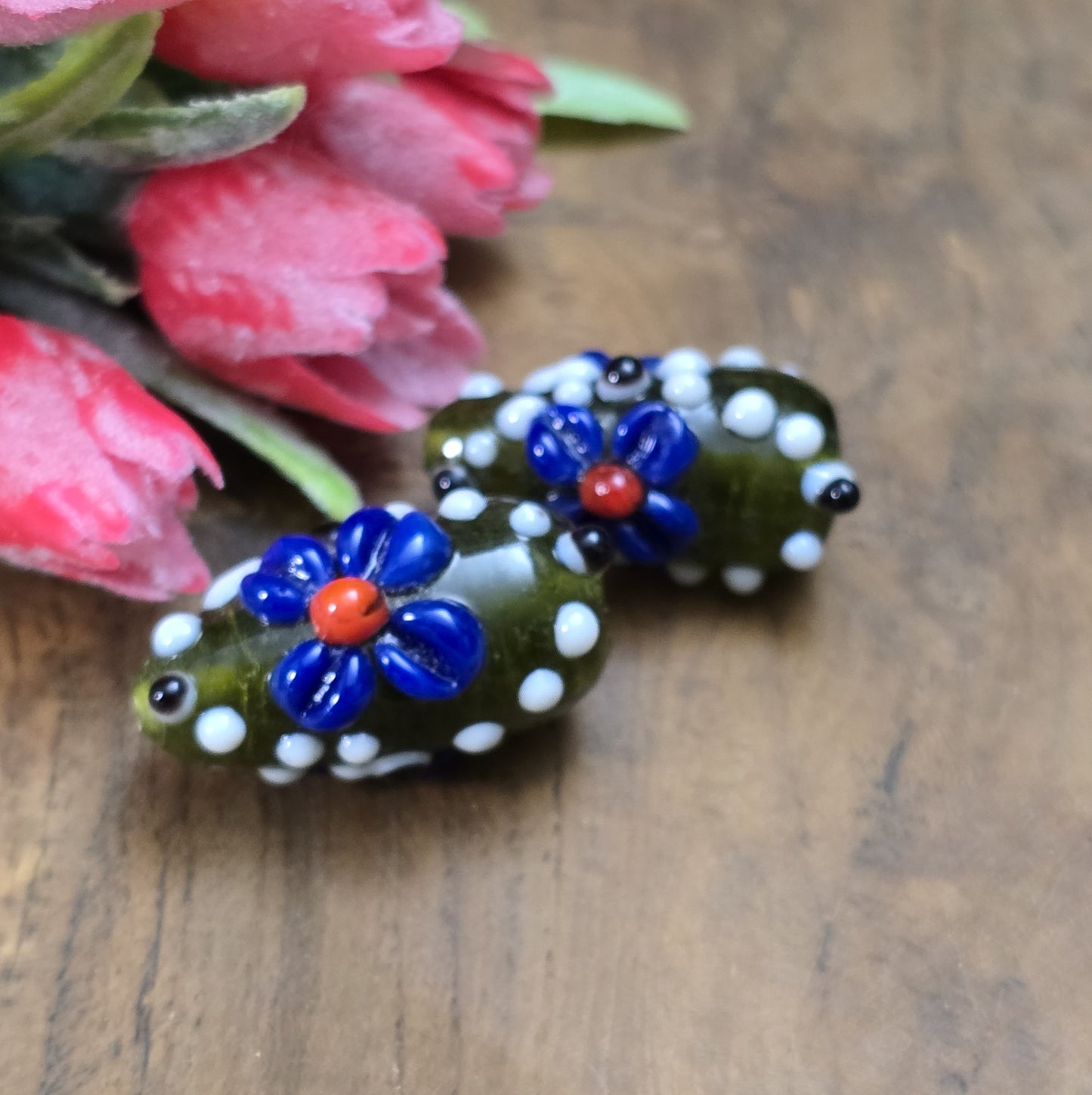 2 Handgemachte indische Glasperlen mit 3D-Blumenmuster in Tropfenform – Dunkelgrün/Blau/Weiß
Diese zauberhaften Glasperlen werden in sorgfältiger Handarbeit gefertigt und bestechen durch ihr opulentes 3D-Muster in Form von Dots und Blumen. Jede Perle ist ein Unikat und bringt einen Hauch traditioneller Handwerkskunst in deine Kreationen.
