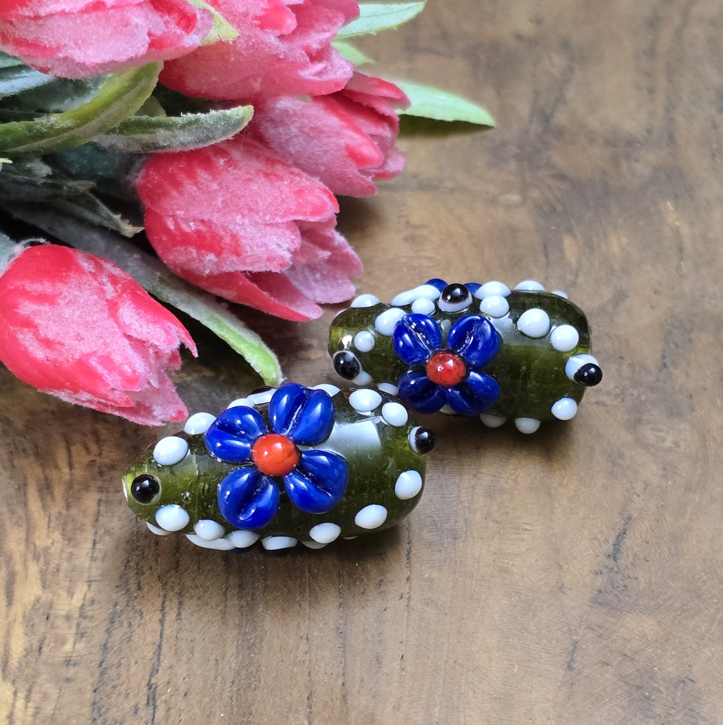 2 Handgemachte indische Glasperlen mit 3D-Blumenmuster in Tropfenform – Dunkelgrün/Blau/Weiß
Diese zauberhaften Glasperlen werden in sorgfältiger Handarbeit gefertigt und bestechen durch ihr opulentes 3D-Muster in Form von Dots und Blumen. Jede Perle ist ein Unikat und bringt einen Hauch traditioneller Handwerkskunst in deine Kreationen.