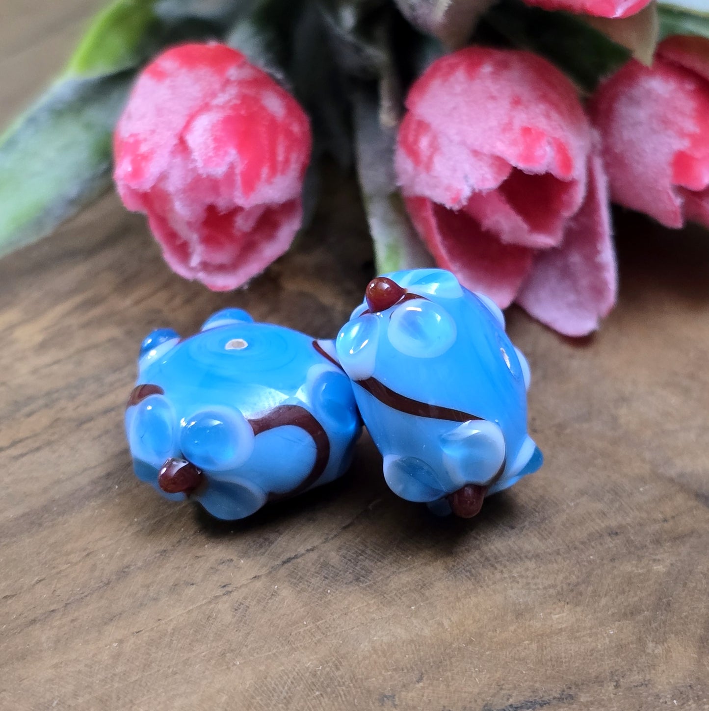 2 Handgemachte indische Glasperlen mit 3D-Blumenmuster – Blau/Rot/Weiß
Diese zauberhaften Glasperlen werden in sorgfältiger Handarbeit gefertigt und bestechen durch ihr filigranes 3D-Blumenmuster. Jede Perle ist ein Unikat und bringt einen Hauch traditioneller Handwerkskunst in deine Kreationen.