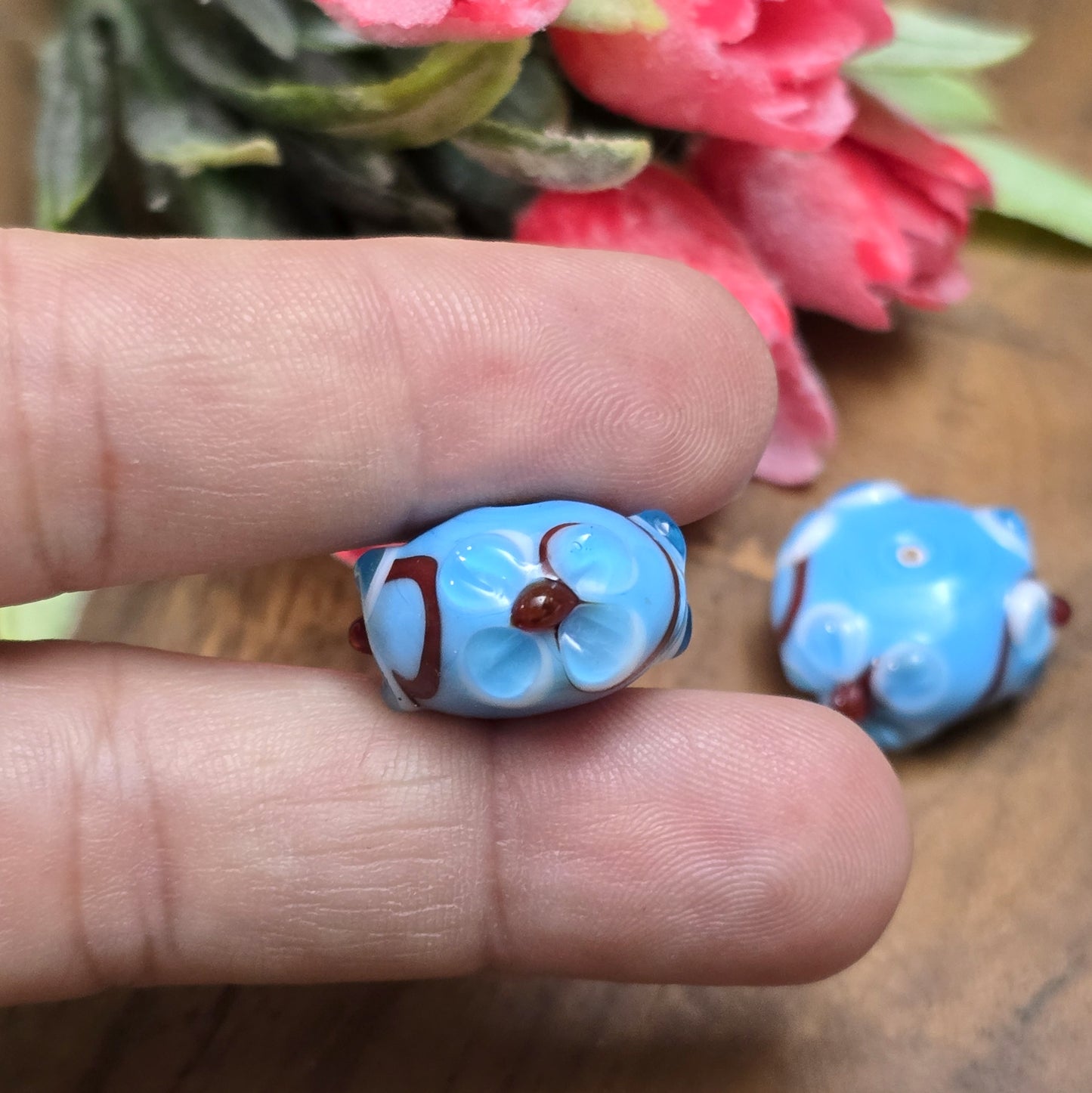 2 Handgemachte indische Glasperlen mit 3D-Blumenmuster – Blau/Rot/Weiß
Diese zauberhaften Glasperlen werden in sorgfältiger Handarbeit gefertigt und bestechen durch ihr filigranes 3D-Blumenmuster. Jede Perle ist ein Unikat und bringt einen Hauch traditioneller Handwerkskunst in deine Kreationen.