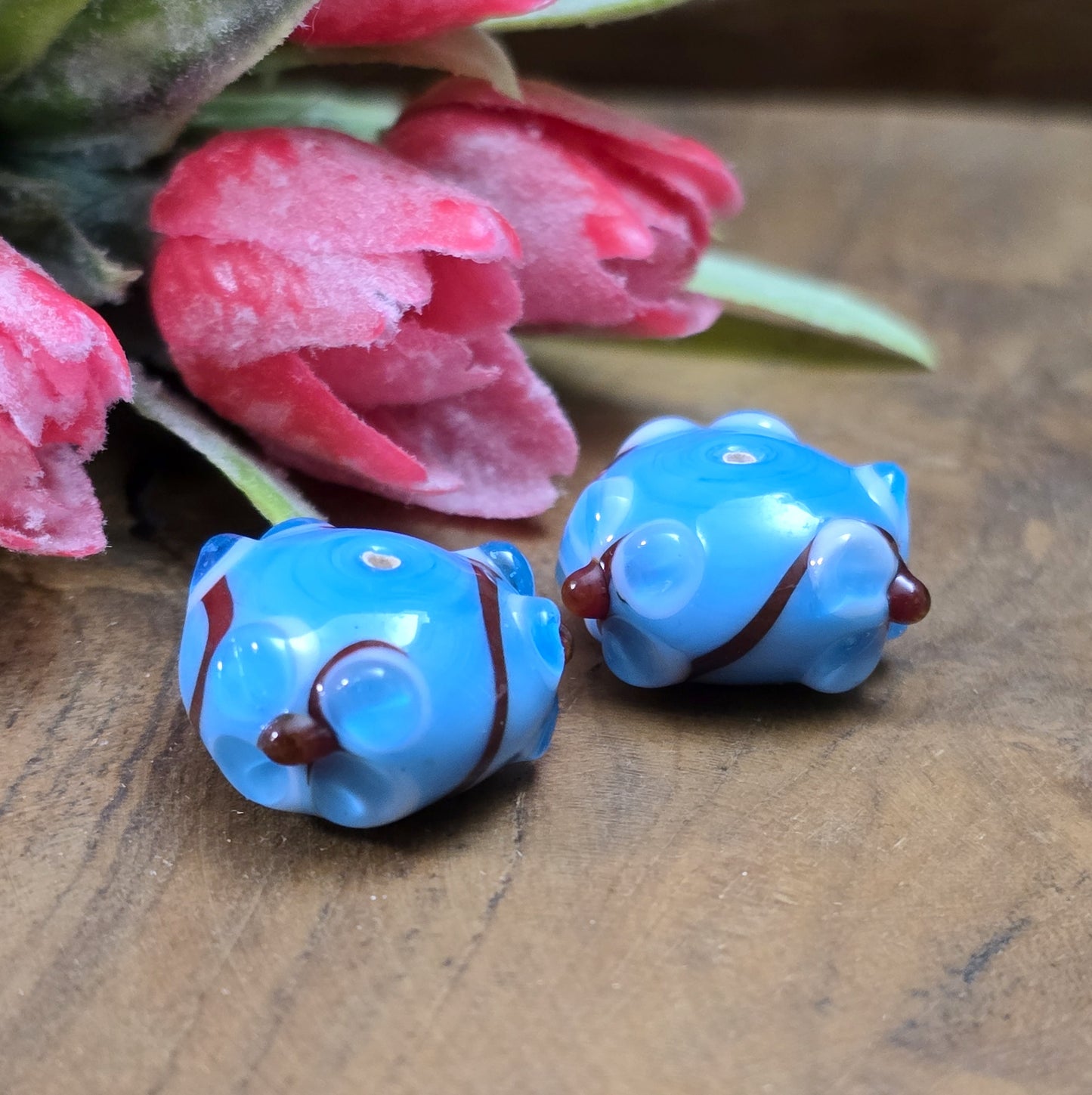 2 Handgemachte indische Glasperlen mit 3D-Blumenmuster – Blau/Rot/Weiß
Diese zauberhaften Glasperlen werden in sorgfältiger Handarbeit gefertigt und bestechen durch ihr filigranes 3D-Blumenmuster. Jede Perle ist ein Unikat und bringt einen Hauch traditioneller Handwerkskunst in deine Kreationen.