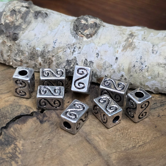Eckige Metallperlen in Antiksilber mit S-förmigem Gravurmuster. Die strukturierte Oberfläche sorgt für einen eleganten Akzent. Mit einer Größe von 11 mm eignen sie sich perfekt für Armbänder, Ketten und kreative Schmuckdesigns.