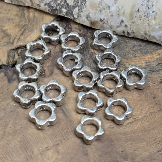 16 Metallperlen in Blumenform, Antiksilber, 8 mm. Jede Perle besticht durch ein filigranes Blumenmuster. Das längs verlaufende Fädelloch ermöglicht einfaches Aufreihen. Perfekt für Armbänder, Ketten oder andere kreative Schmuckideen. Set: 16 Stück.