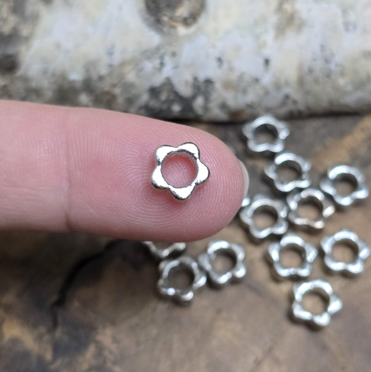 16 Metallperlen in Blumenform, Antiksilber, 8 mm. Jede Perle besticht durch ein filigranes Blumenmuster. Das längs verlaufende Fädelloch ermöglicht einfaches Aufreihen. Perfekt für Armbänder, Ketten oder andere kreative Schmuckideen. Set: 16 Stück.