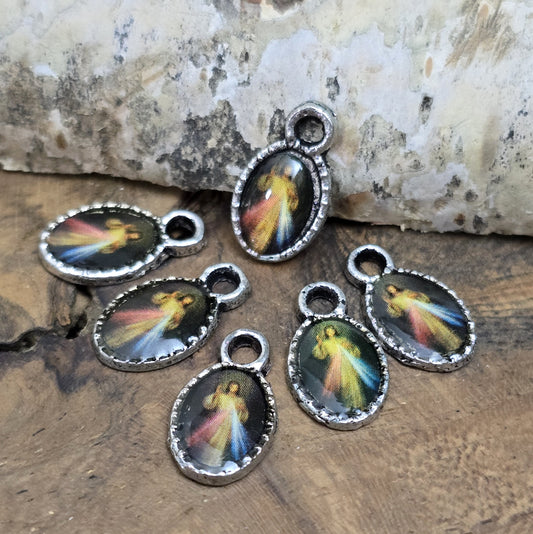 Diese kleinen Anhänger zeigen ein Bildnis von Jesus. Das Bild ist versiegelt mit Kunstharz um es vor Beschädigungen zu schützen. Auf der Rückseite befindet sich ein Kreuz. Ideal für Armbänder, Ohrschmuck und andere kreative Anwendungen. 