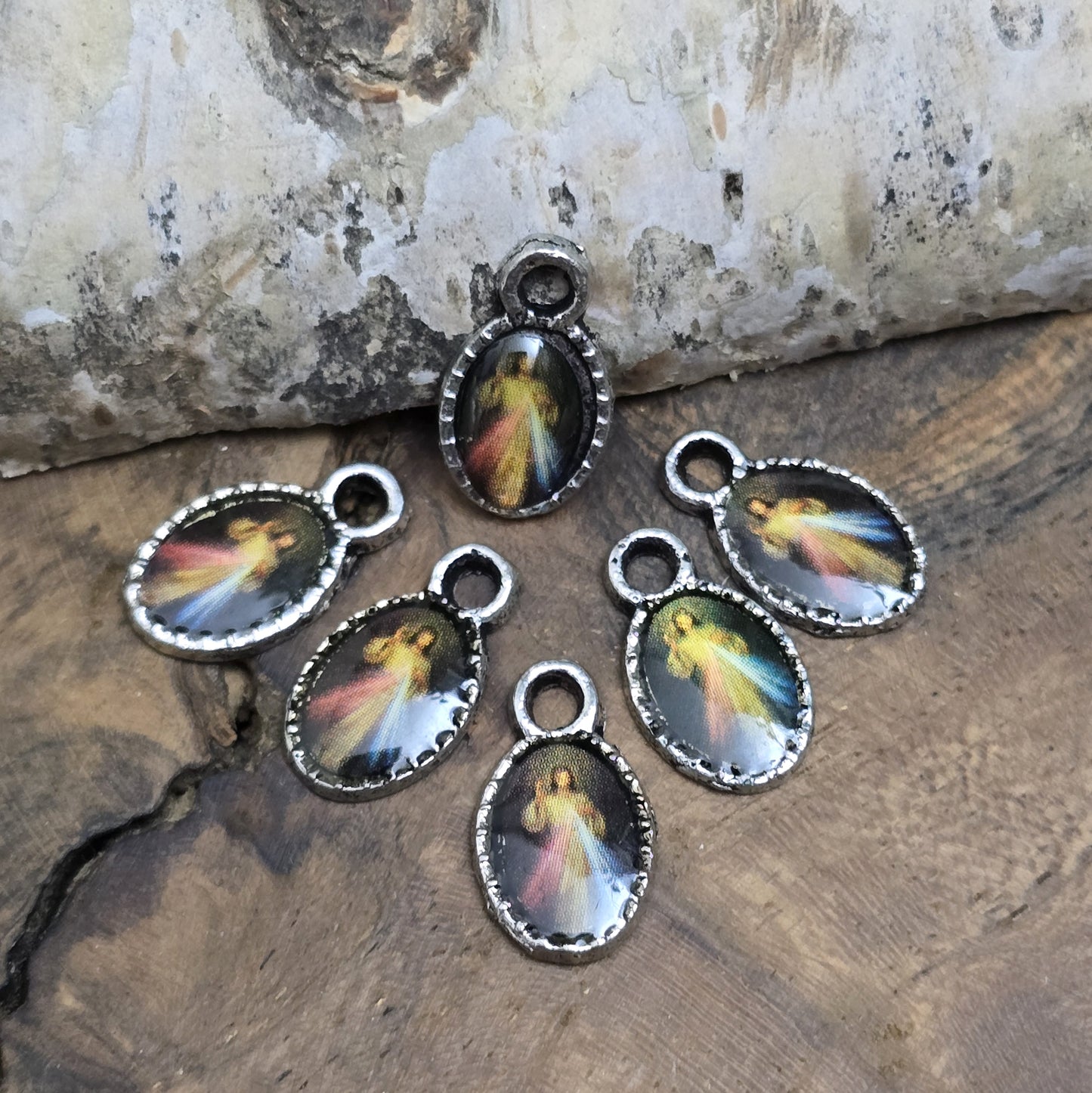 Diese kleinen Anhänger zeigen ein Bildnis von Jesus. Das Bild ist versiegelt mit Kunstharz um es vor Beschädigungen zu schützen. Auf der Rückseite befindet sich ein Kreuz. Ideal für Armbänder, Ohrschmuck und andere kreative Anwendungen. 