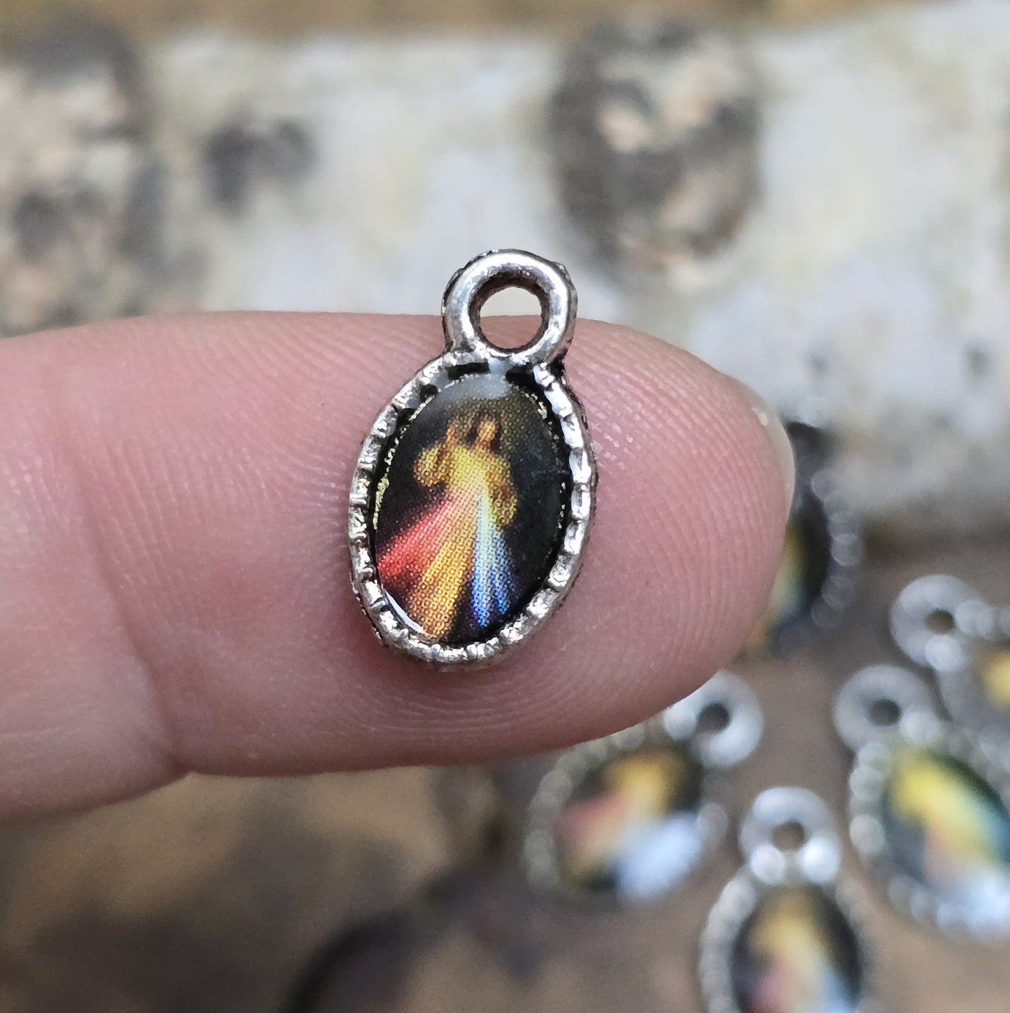 Diese kleinen Anhänger zeigen ein Bildnis von Jesus. Das Bild ist versiegelt mit Kunstharz um es vor Beschädigungen zu schützen. Auf der Rückseite befindet sich ein Kreuz. Ideal für Armbänder, Ohrschmuck und andere kreative Anwendungen. 