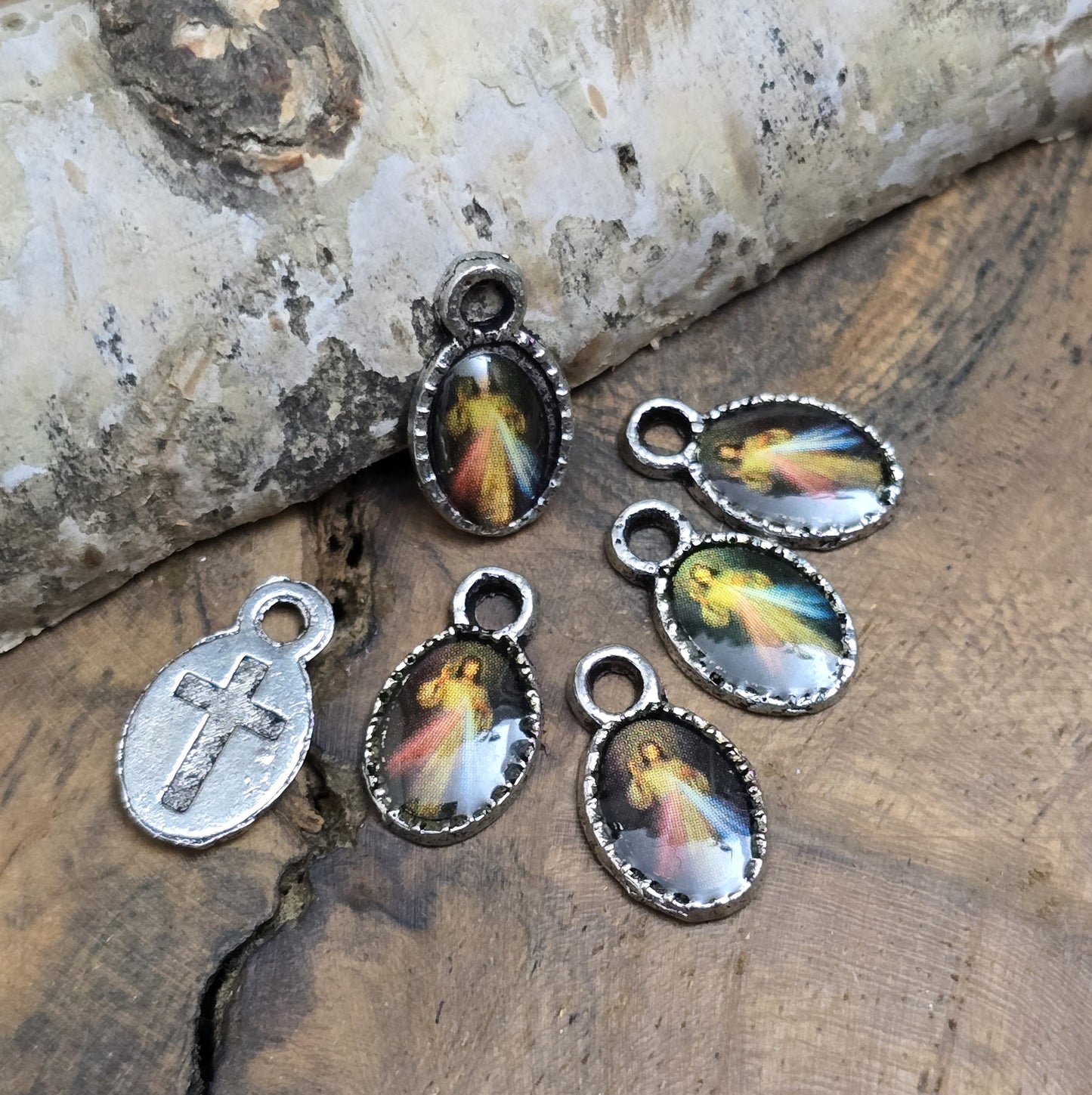 Diese kleinen Anhänger zeigen ein Bildnis von Jesus. Das Bild ist versiegelt mit Kunstharz um es vor Beschädigungen zu schützen. Auf der Rückseite befindet sich ein Kreuz. Ideal für Armbänder, Ohrschmuck und andere kreative Anwendungen. 