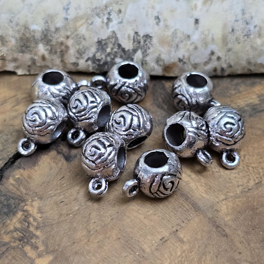 10 runde Metallperlen in Antiksilber mit Rosenmotiv und großer Öse. Größe: 8 x 12 mm, Fädelloch: 4 mm. Perfekt für Armbänder, Ketten und zum Befestigen kleiner Anhänger. Ideal für romantische Schmuckdesigns und traditionelle Kreationen.