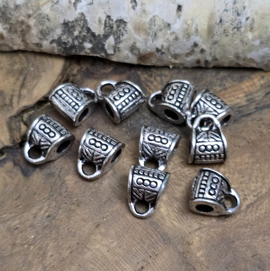 10 Metallperlen mit Öse, antiksilberfarben, 7 x 9 mm. Jede Perle ist mit einem feinen Ethnomuster verziert. Das große Fädelloch (ca. 3 mm) ermöglicht einfaches Auffädeln. Mit der Öse können Anhänger befestigt werden. Perfekt für Armbänder, Ketten und kreative Designs.