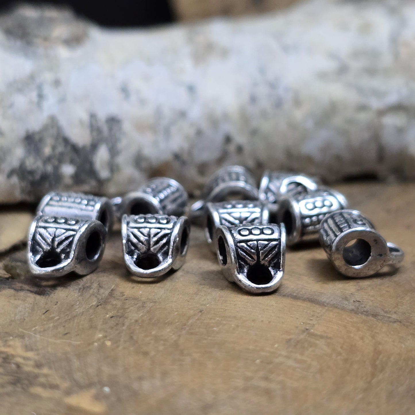 10 Metallperlen mit Öse, antiksilberfarben, 7 x 9 mm. Jede Perle ist mit einem feinen Ethnomuster verziert. Das große Fädelloch (ca. 3 mm) ermöglicht einfaches Auffädeln. Mit der Öse können Anhänger befestigt werden. Perfekt für Armbänder, Ketten und kreative Designs.