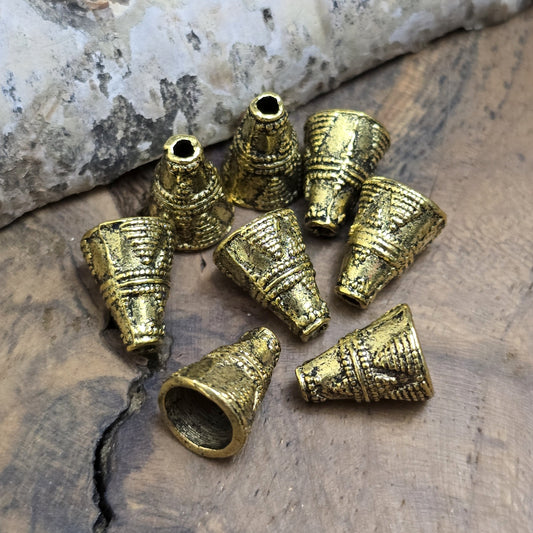 4 konische Kappen aus Metall, Ethnodesign, 11x8mm, antik goldfarbig
Diese konischen Kappen aus Metall bieten einen stilvollen Abschluss für Perlen, Ketten oder Armbänder. Sie sind auch ideal, um Perlen vor dem Anstoßen zu schützen und verleihen deinem Schmuck oder Accessoire eine geheimnisvolle Note.