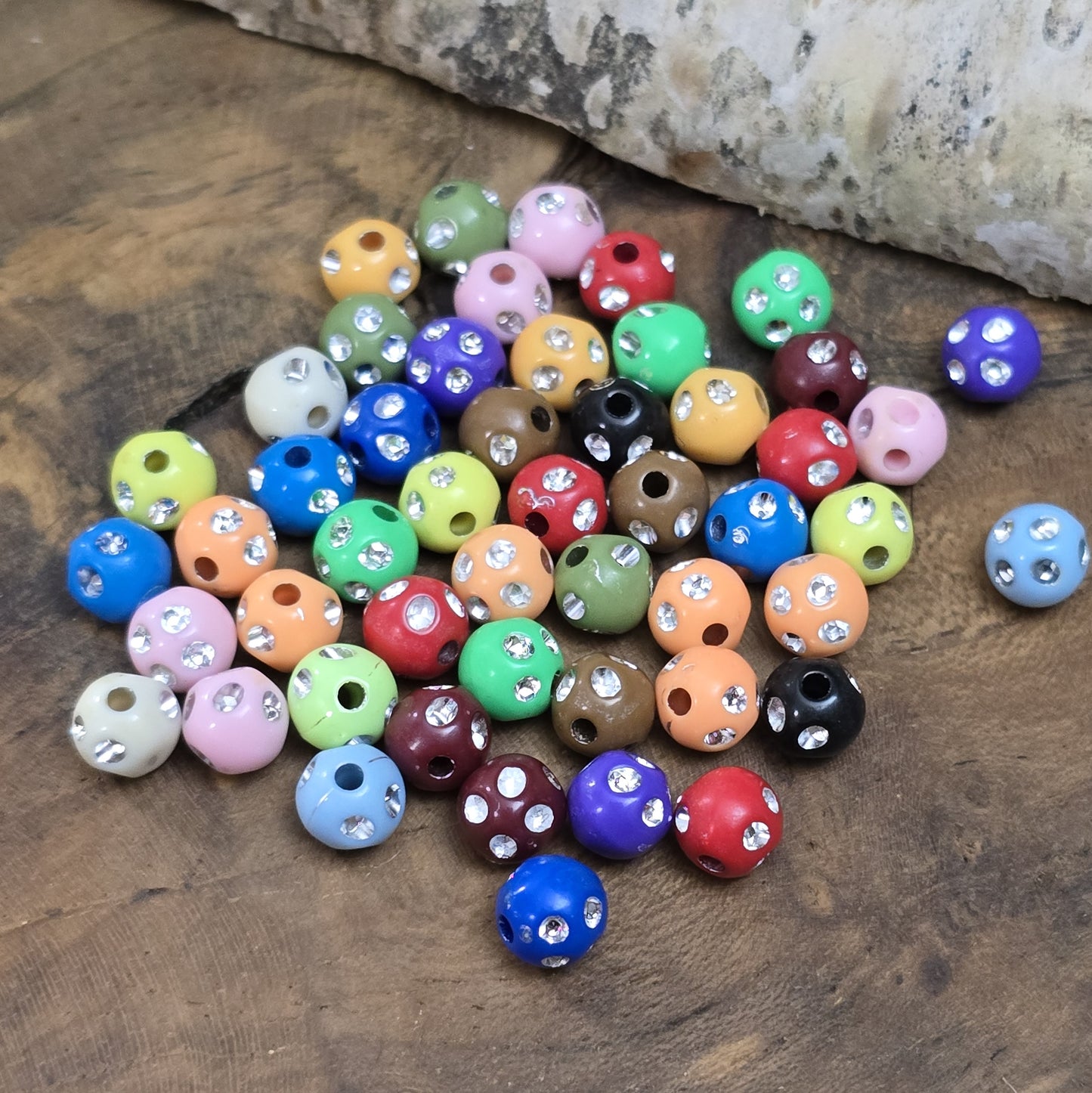 100 bunte Acrylperlen im Strasslook, 6mm. Die Perlen haben eine glänzende Oberfläche und lebendige Farben. Perfekt für Schmuck, Makramee oder Dekorationen. Mit großem Fädelloch für einfaches Auffädeln auf Bänder oder Schnüre.