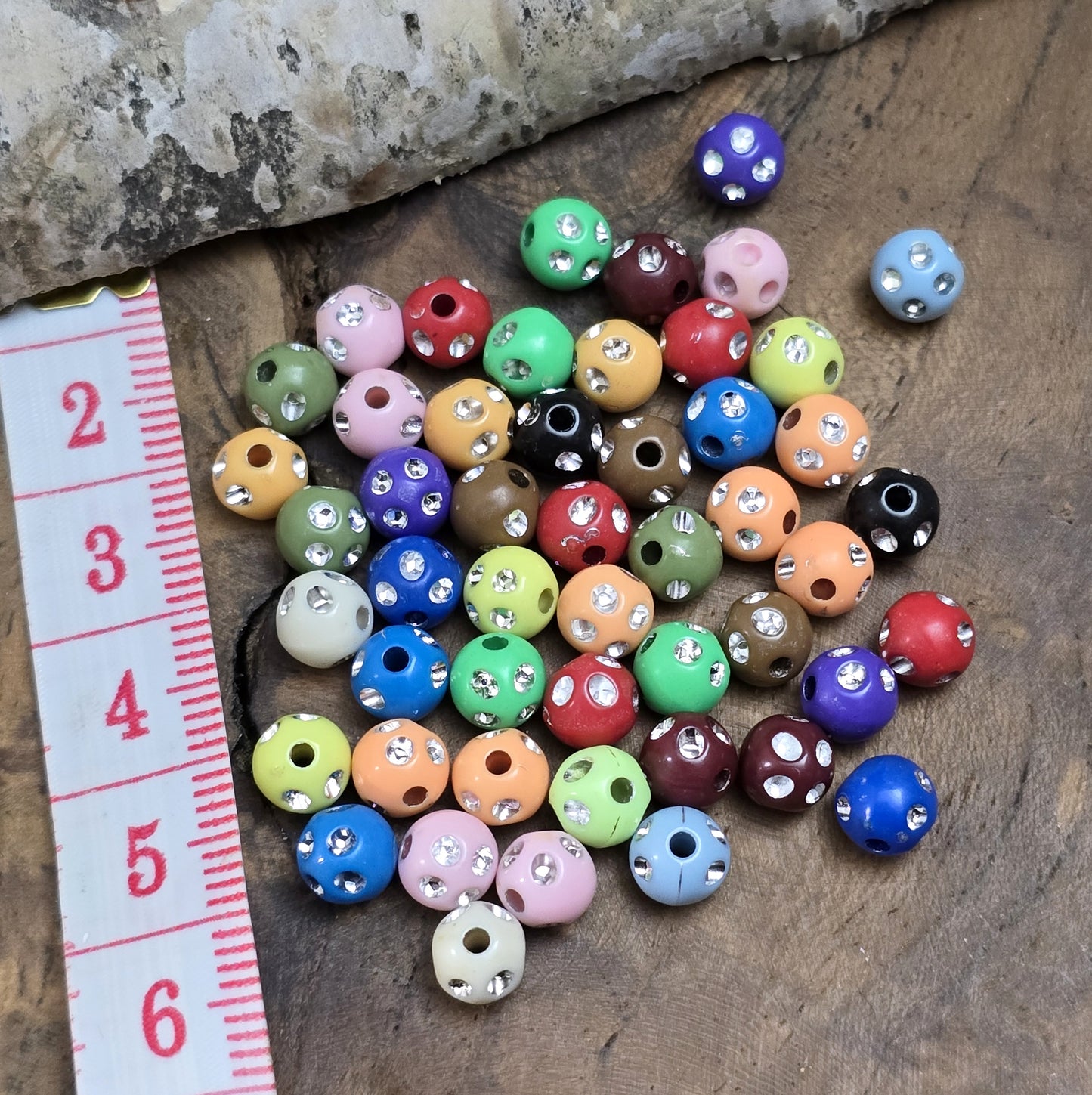 100 bunte Acrylperlen im Strasslook, 6mm. Die Perlen haben eine glänzende Oberfläche und lebendige Farben. Perfekt für Schmuck, Makramee oder Dekorationen. Mit großem Fädelloch für einfaches Auffädeln auf Bänder oder Schnüre.