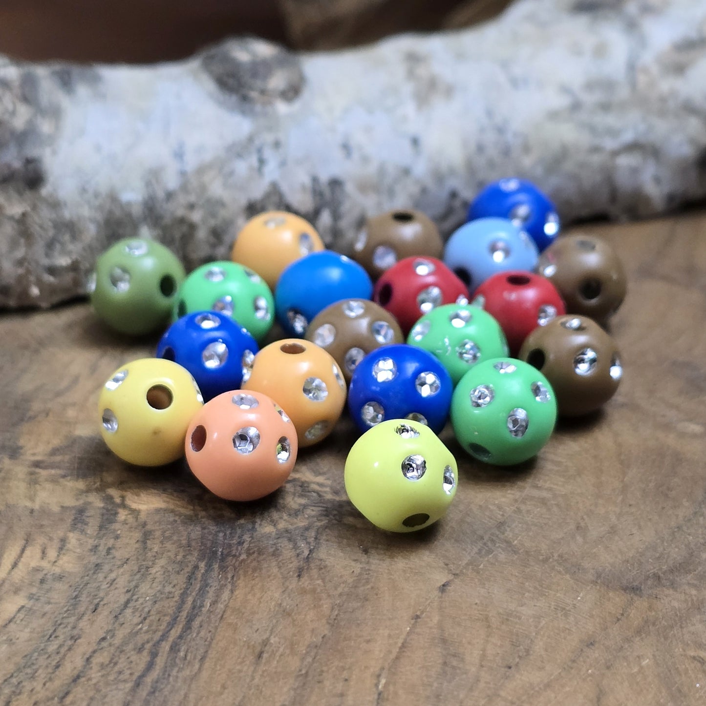 100 bunte Acrylperlen im Strasslook, 6mm. Die Perlen haben eine glänzende Oberfläche und lebendige Farben. Perfekt für Schmuck, Makramee oder Dekorationen. Mit großem Fädelloch für einfaches Auffädeln auf Bänder oder Schnüre.